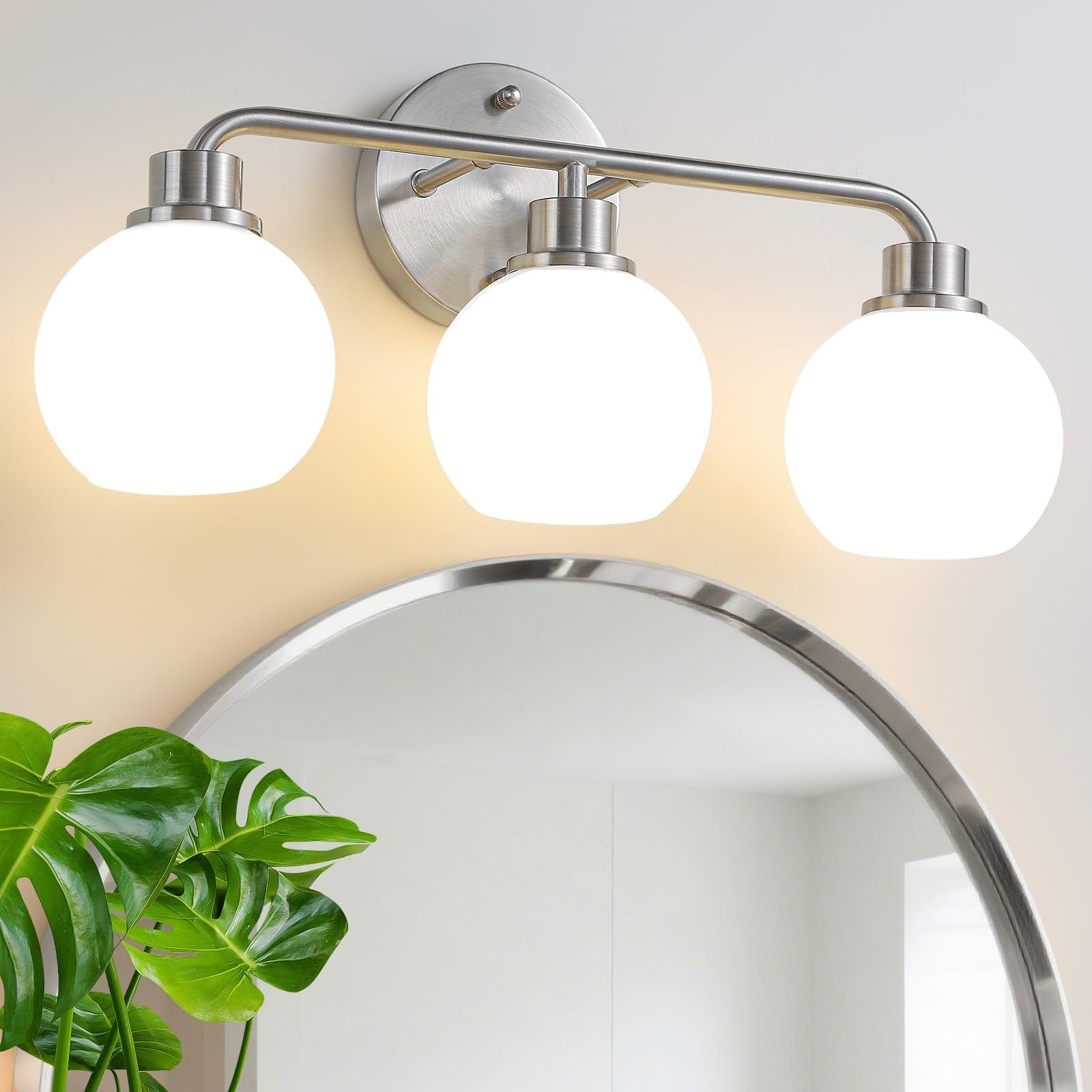 Watyo brushed nickel bathroom vanity light fixture with three wall sconces and clear glass shades.