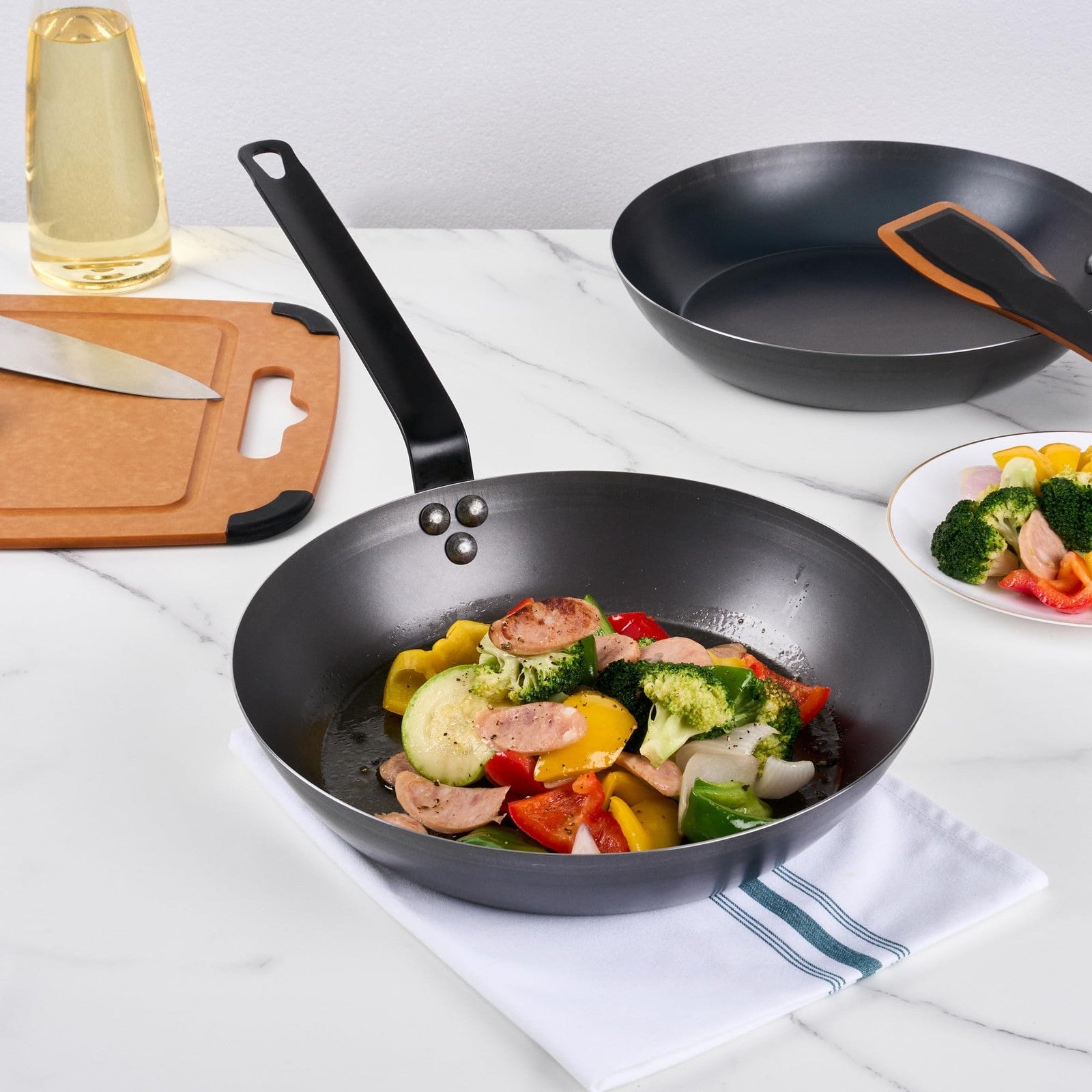 Restaurantware Met Lux 12-inch lightweight frying pan with triple-rive design, induction-ready, shown on stovetop.