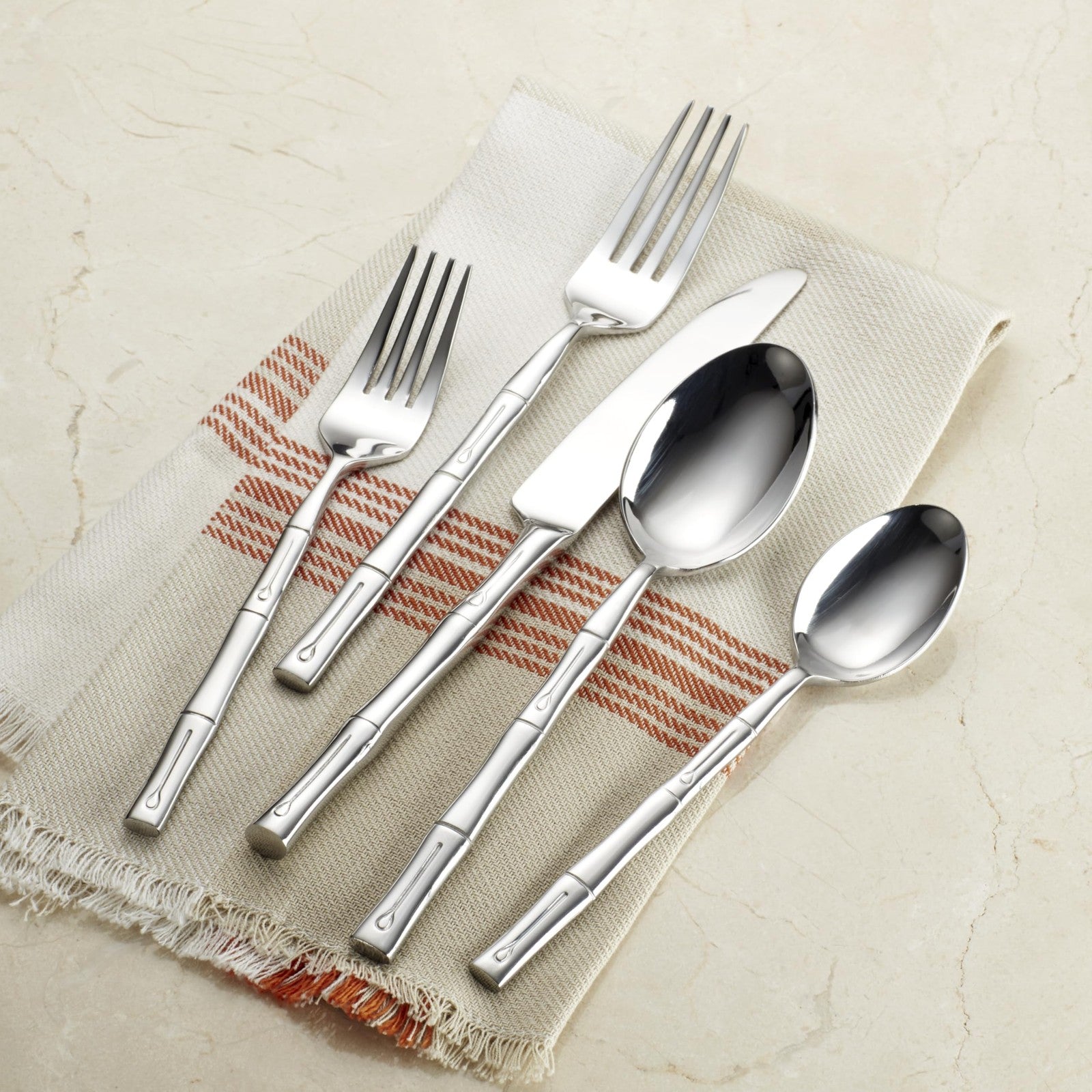Hampton Forge Hampton Signature bamboo 20-piece flatware set for 4 with forks, knives, spoons, and serving pieces on a table.