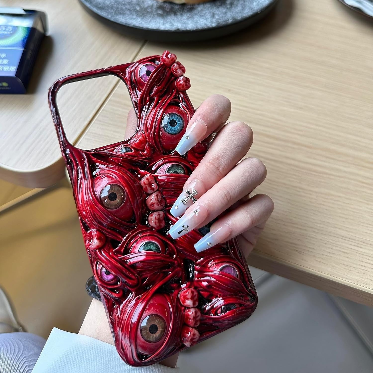 TRADAY horror phone case with 3D creepy eyes for iPhone 16 Pro, featuring a spooky, detailed design on black background.