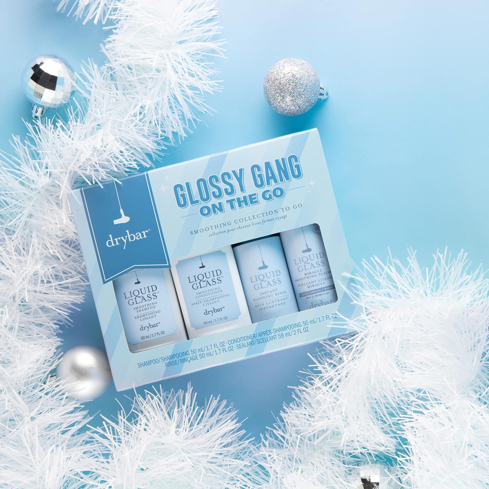 Drybar Glossy Gang on-the-go kit with small bottles of frizz control and shine serum for travel-ready hair styling.