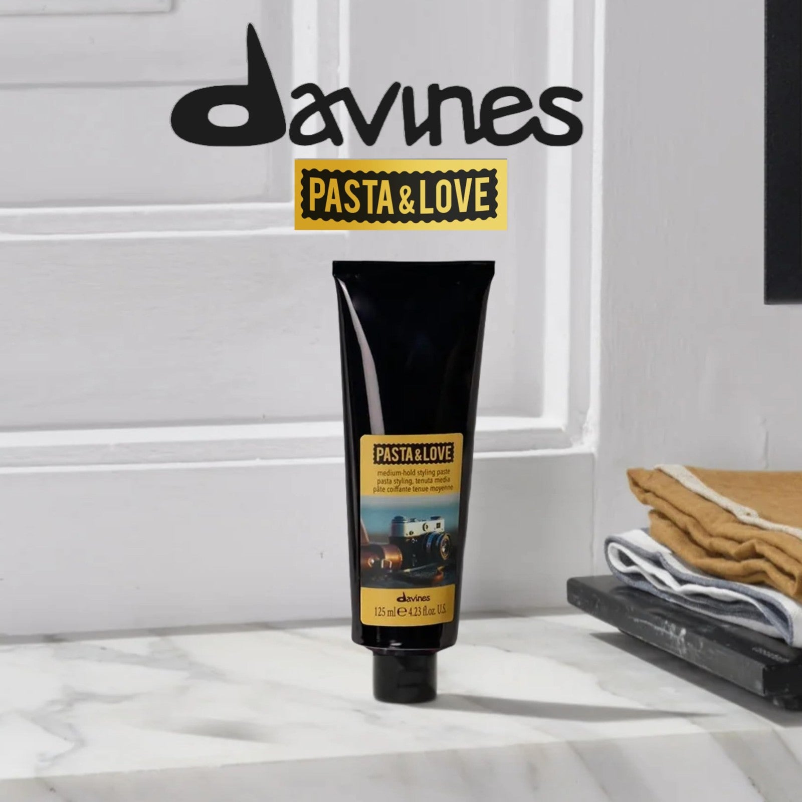 Davines Pasta & Love medium-hold styling paste in a natural hair paste form, shown in a jar with a creamy texture.
