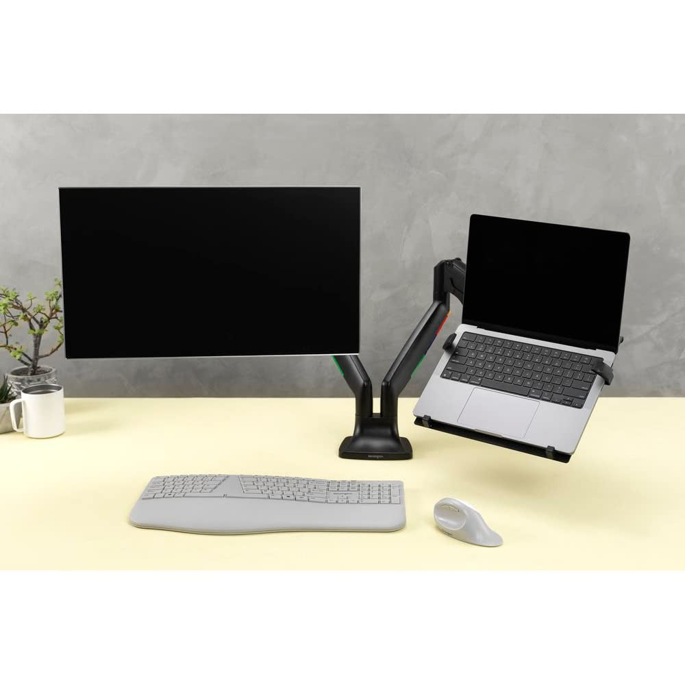 Kensington VESA-mount laptop holder attached to monitor arm for secure, adjustable laptop support in workspace setup