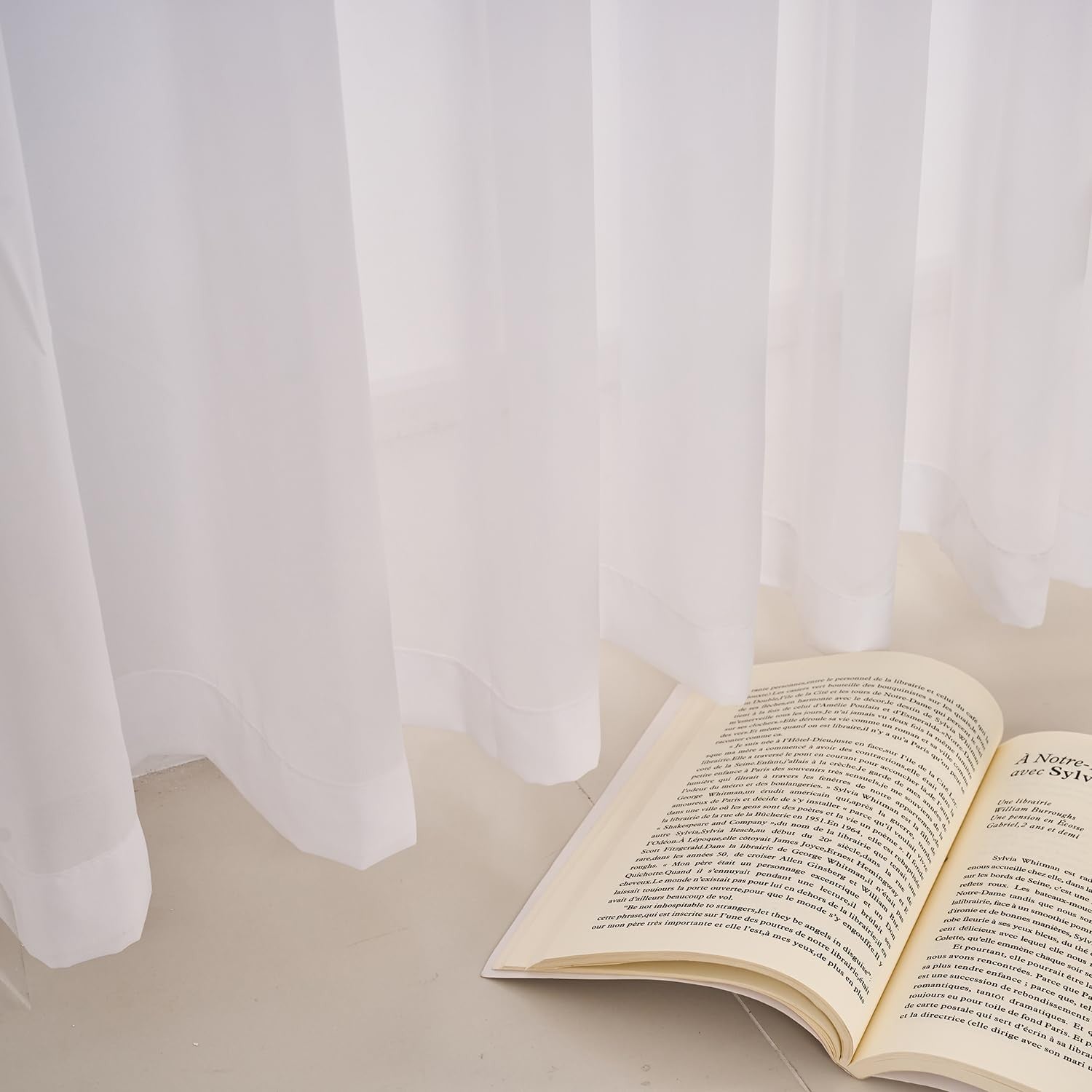 LUGOTAL Pure White 90-inch long pinch pleated chiffon sheer curtains hanging in a window, showcasing elegant lightweight fabric.