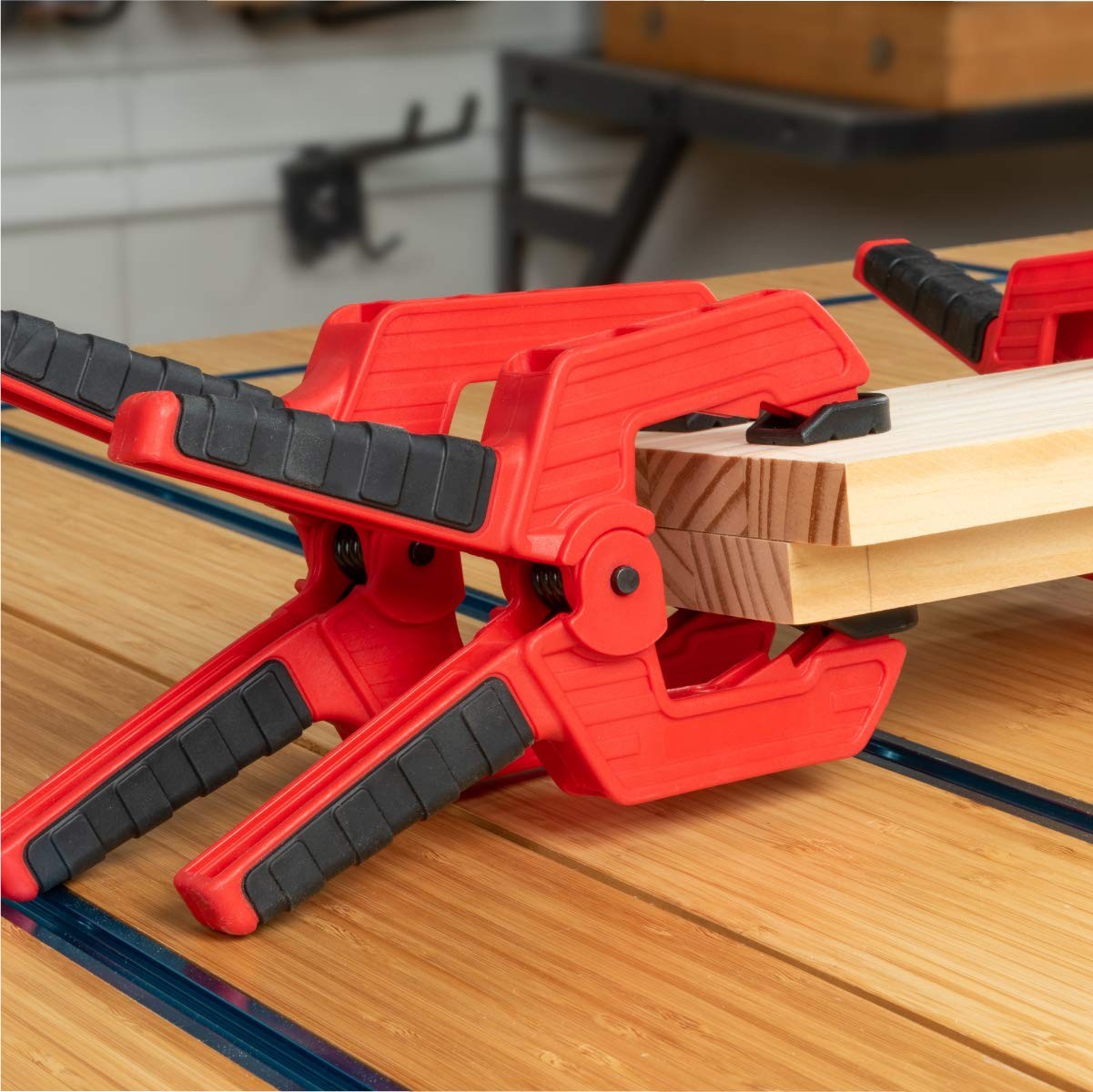 POWERTEC 72208 Deluxe Quick Release Strap Clamp and Spring Clamps set for woodworking projects, showing clamps in use on wood pieces.