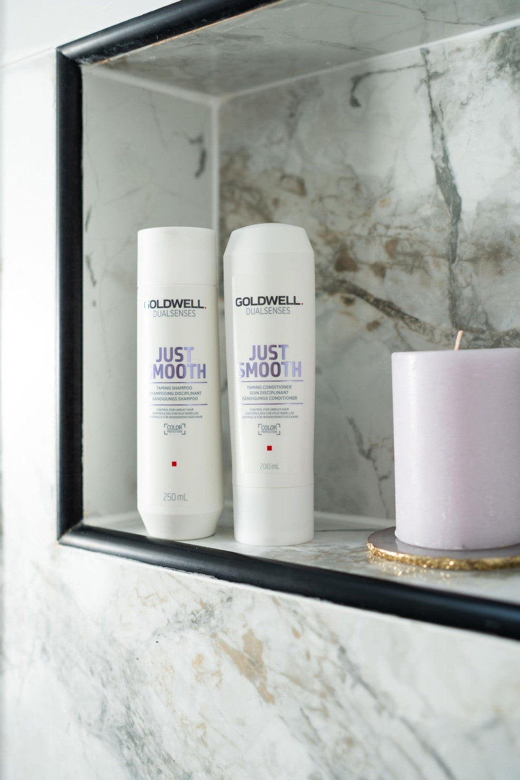 Goldwell Dualsenses Just Smooth anti-frizz conditioner bottle with label and gold cap, designed for humidity control and smooth hair.