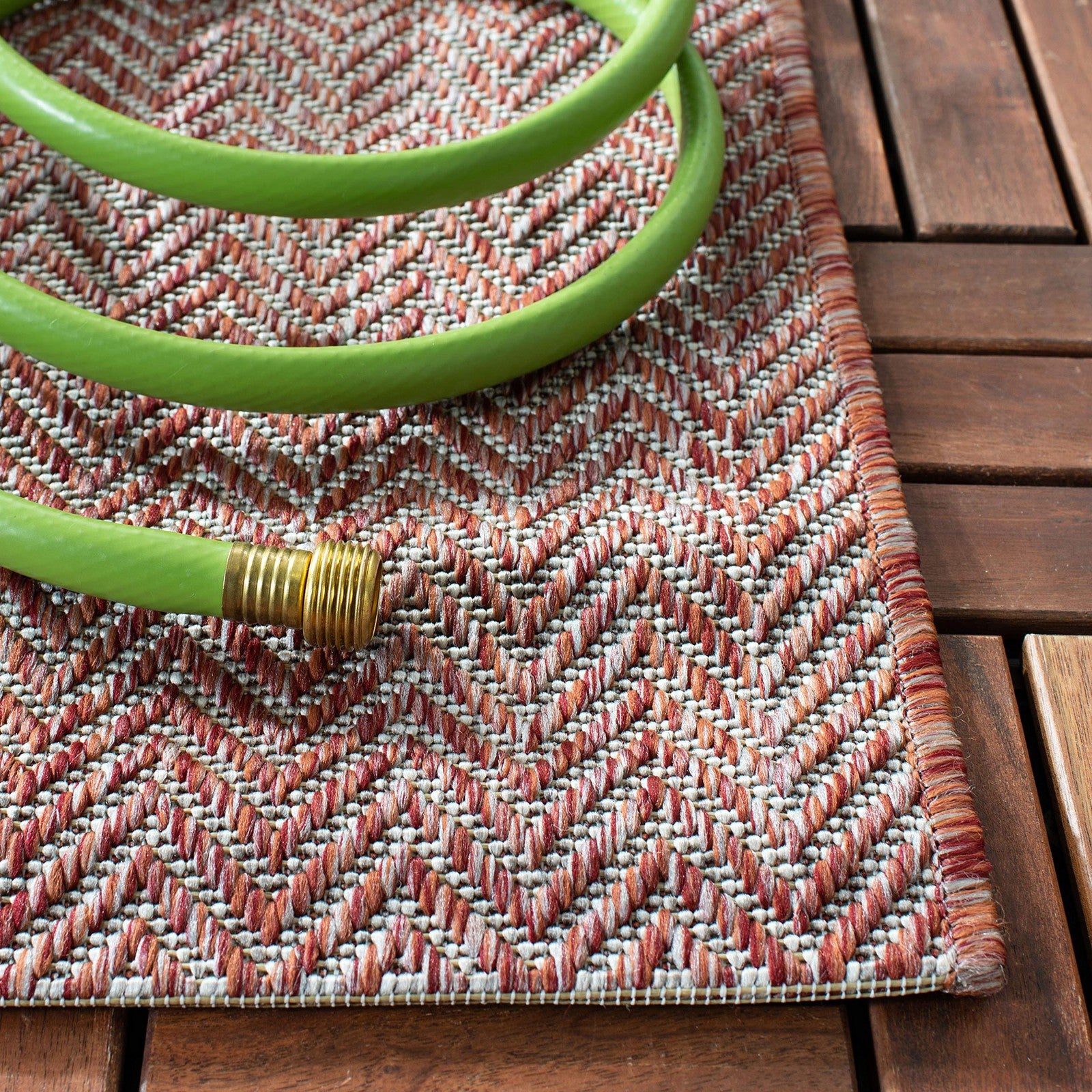 Safavieh washable outdoor rug from the Courtyard Collection, square shape with red and beige geometric pattern on a patio floor