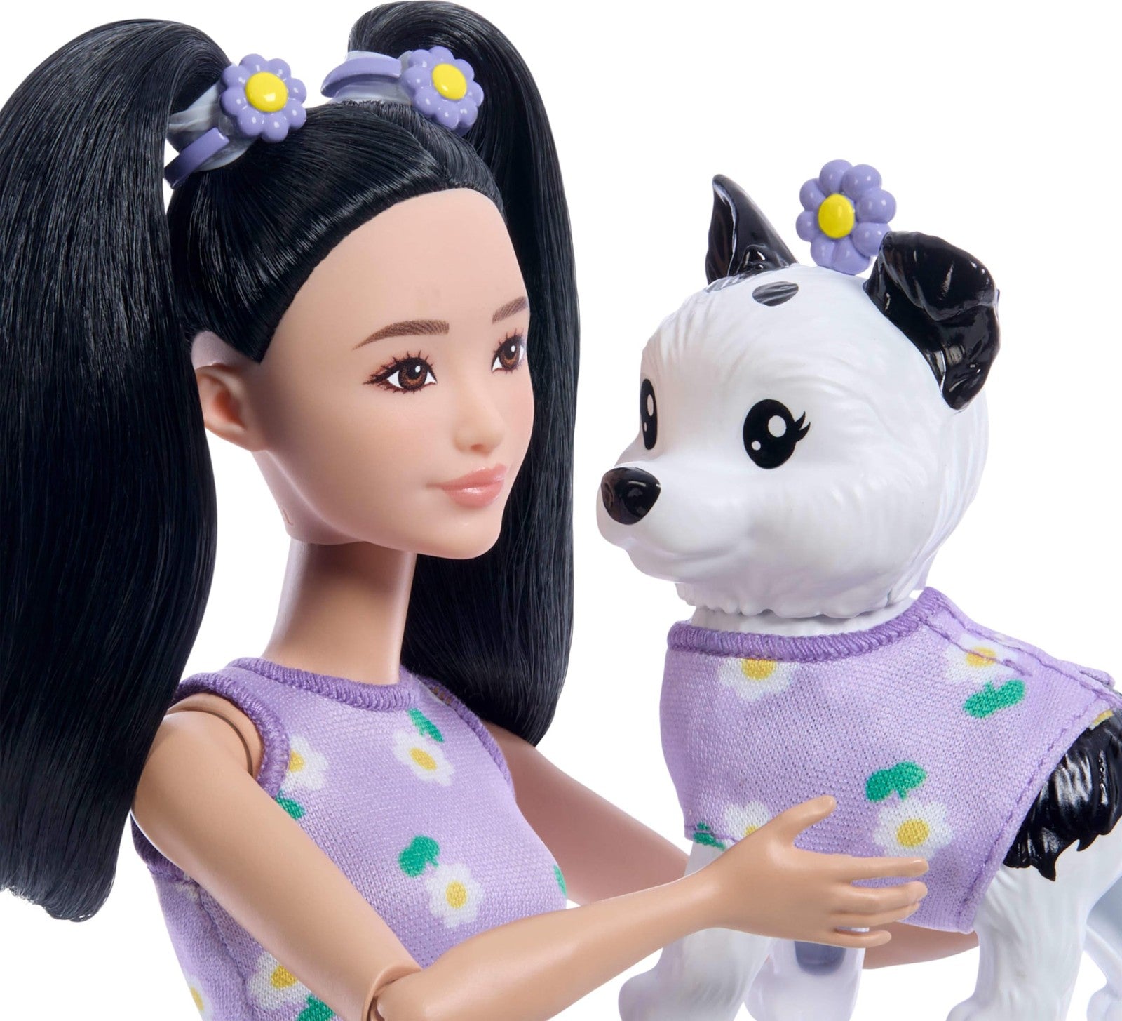 Barbie Twinning Looks doll and pet dog wearing matching purple daisy outfits, showcasing coordinated fashion and accessories.