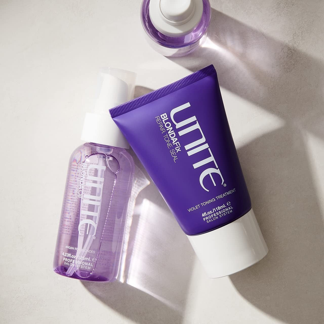 UNITE Hair Blonda Fix Ultra-Violet Repair Treatment for blonde hair, showing a sleek bottle with purple-toned formula inside.