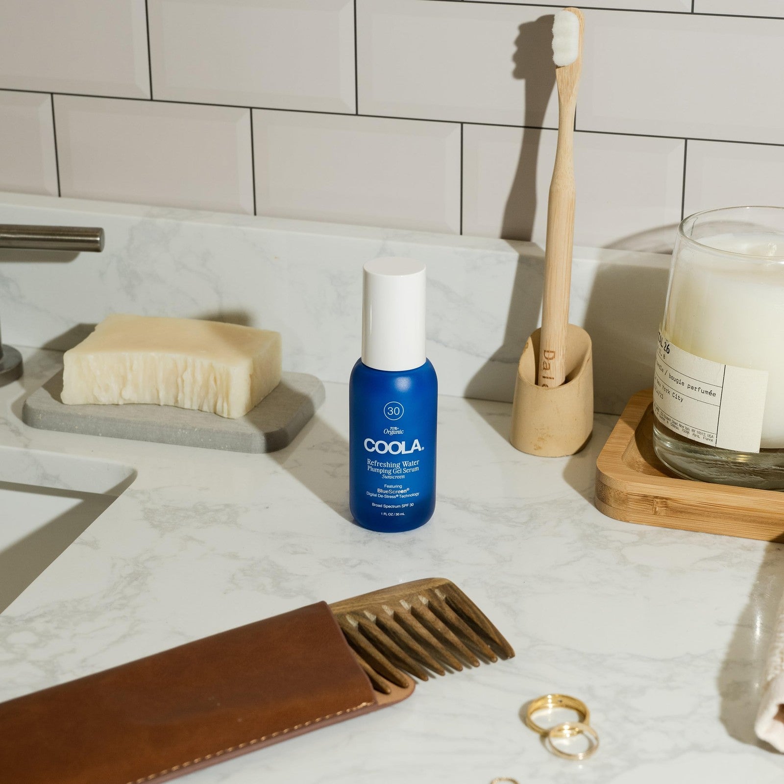 COOLA Refreshing Water Plumping Gel with SPF 30 and dermatologist testing, shown in a clear jar with a blue lid and gel texture.