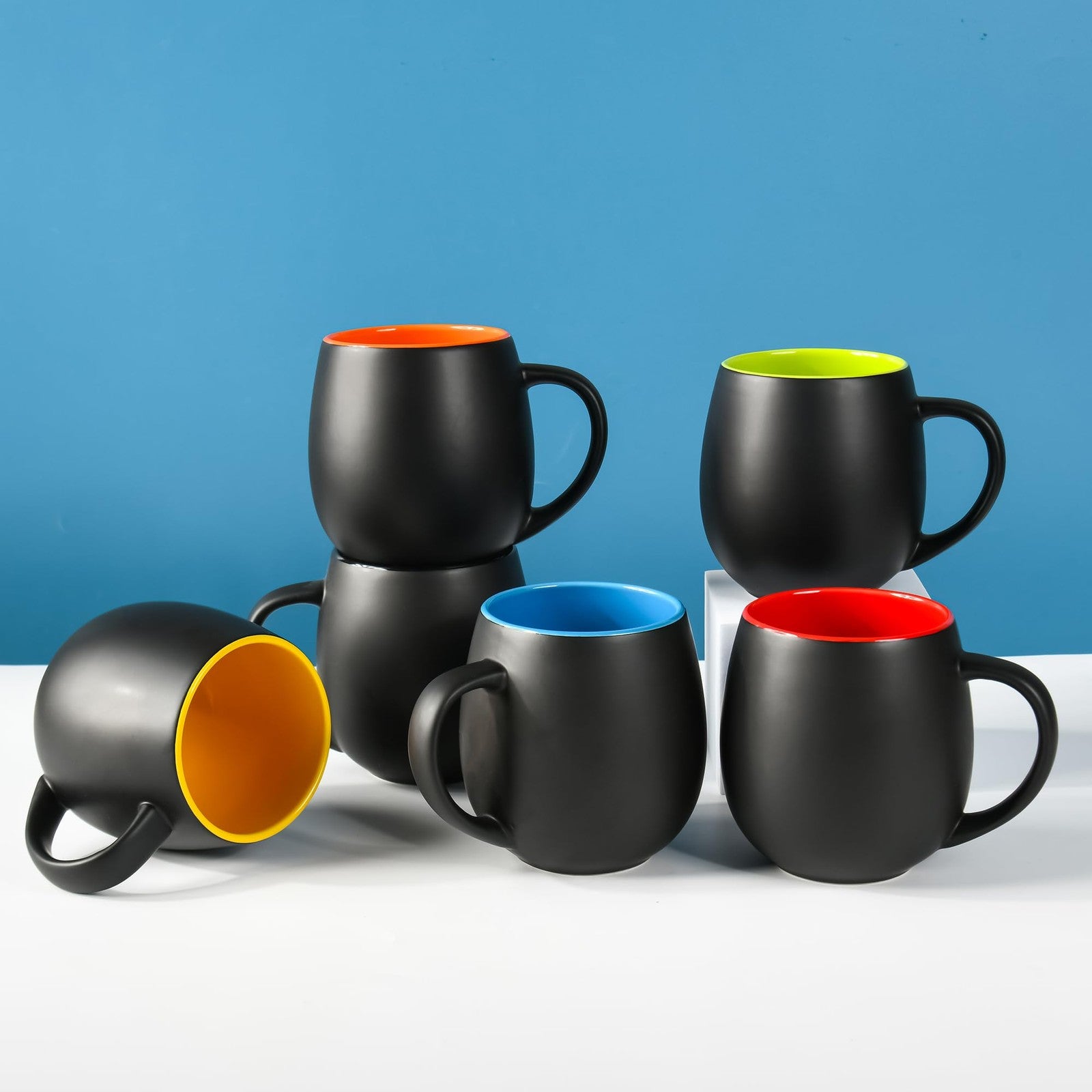 BYCNZB 20oz matte black ceramic coffee mug set with multiple colorful porcelain mugs on a white background
