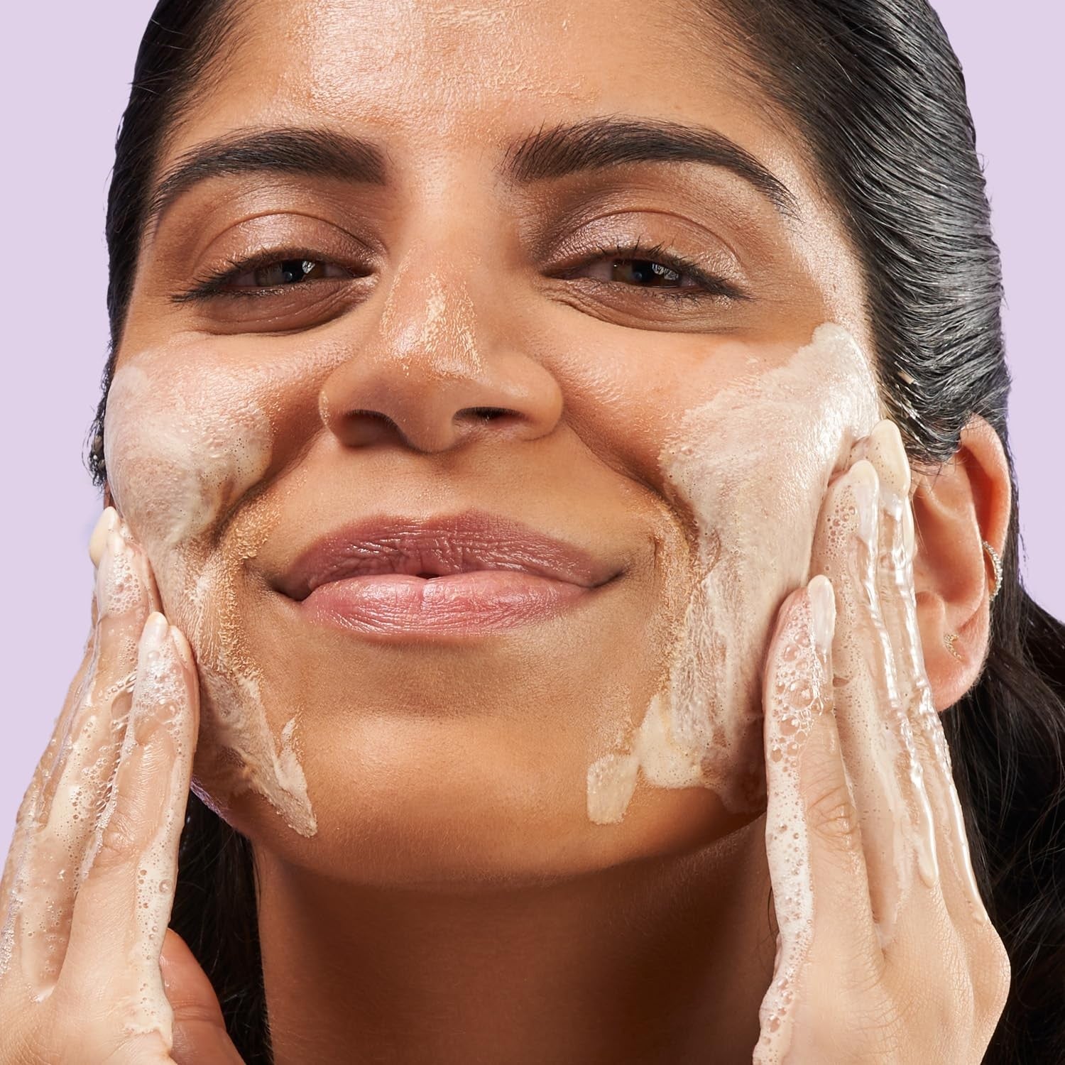 EXUVIANCE 3-in-1 Clarifying Anti-Aging Cleanser for acne-prone skin with salicylic acid, visible in a clear bottle with pump dispenser.