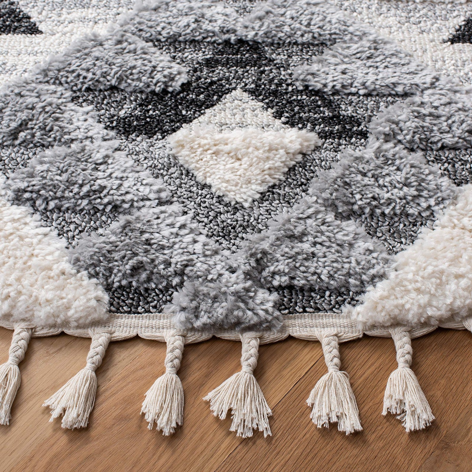Safavieh Moroccan Tassel Shag Area Rug, 53-inch round in ivory and grey with boho design and tassel accents, soft and plush texture.