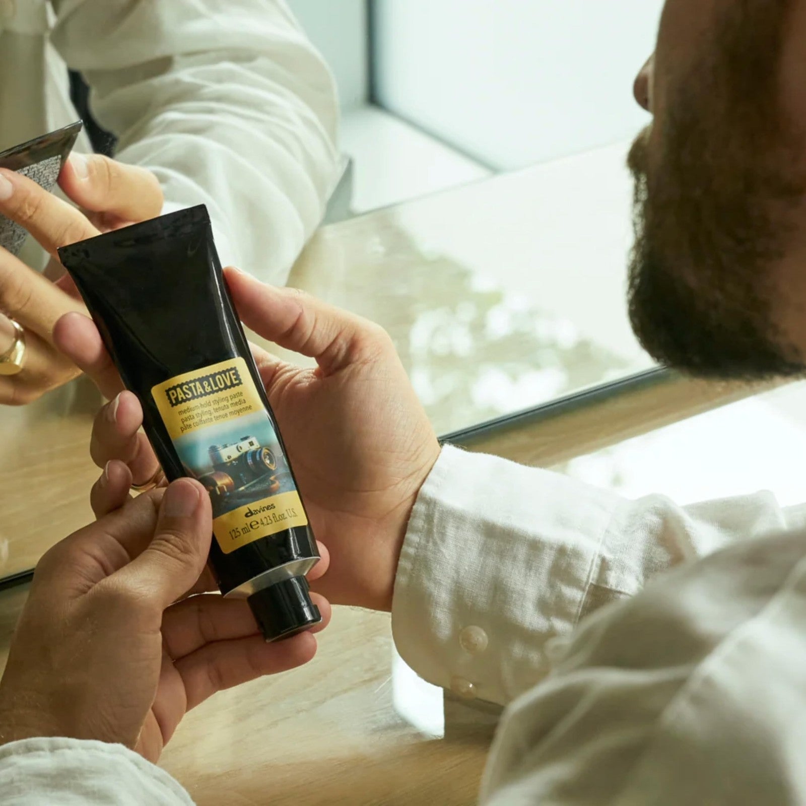 Davines Pasta & Love medium-hold styling paste in a jar, showcasing its natural, workable hair styling product.
