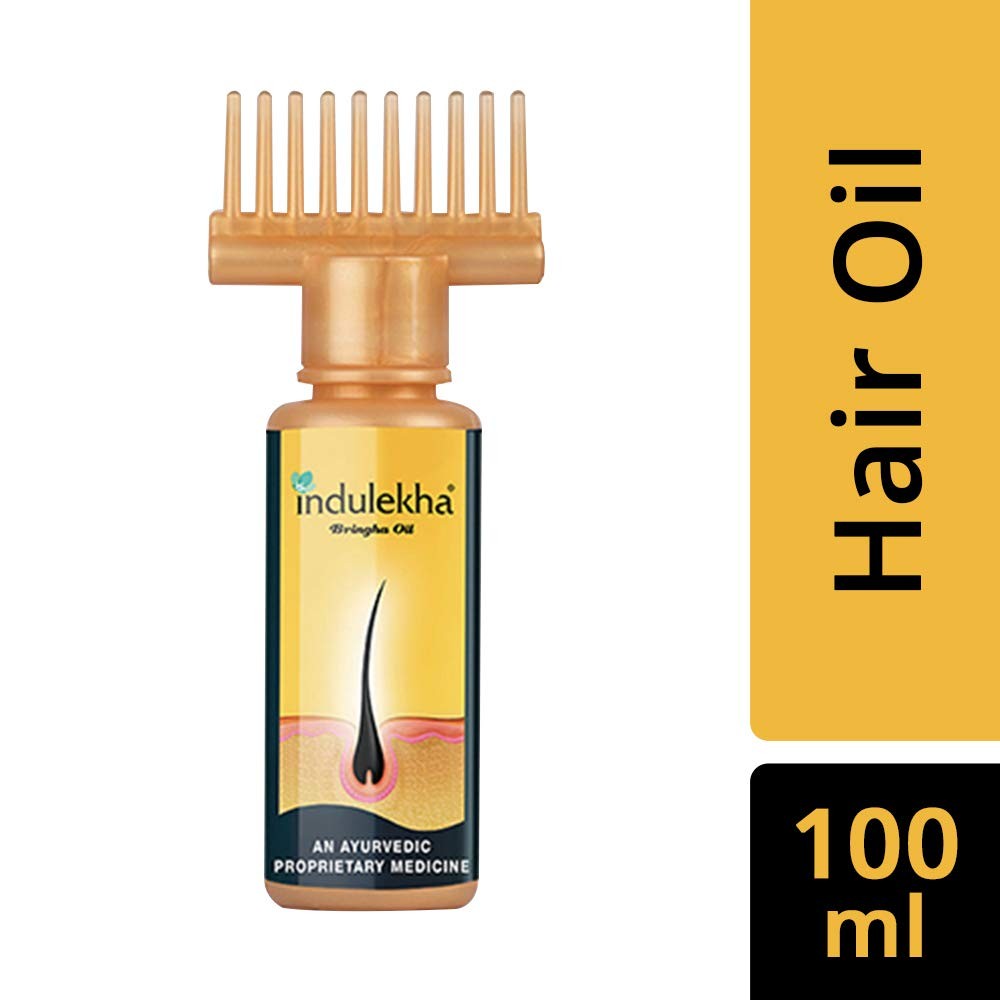 Two bottles of Indulekha Bringha Complete Hair Care Oil, 100ml each, with herbal ingredients visible in the transparent bottles.
