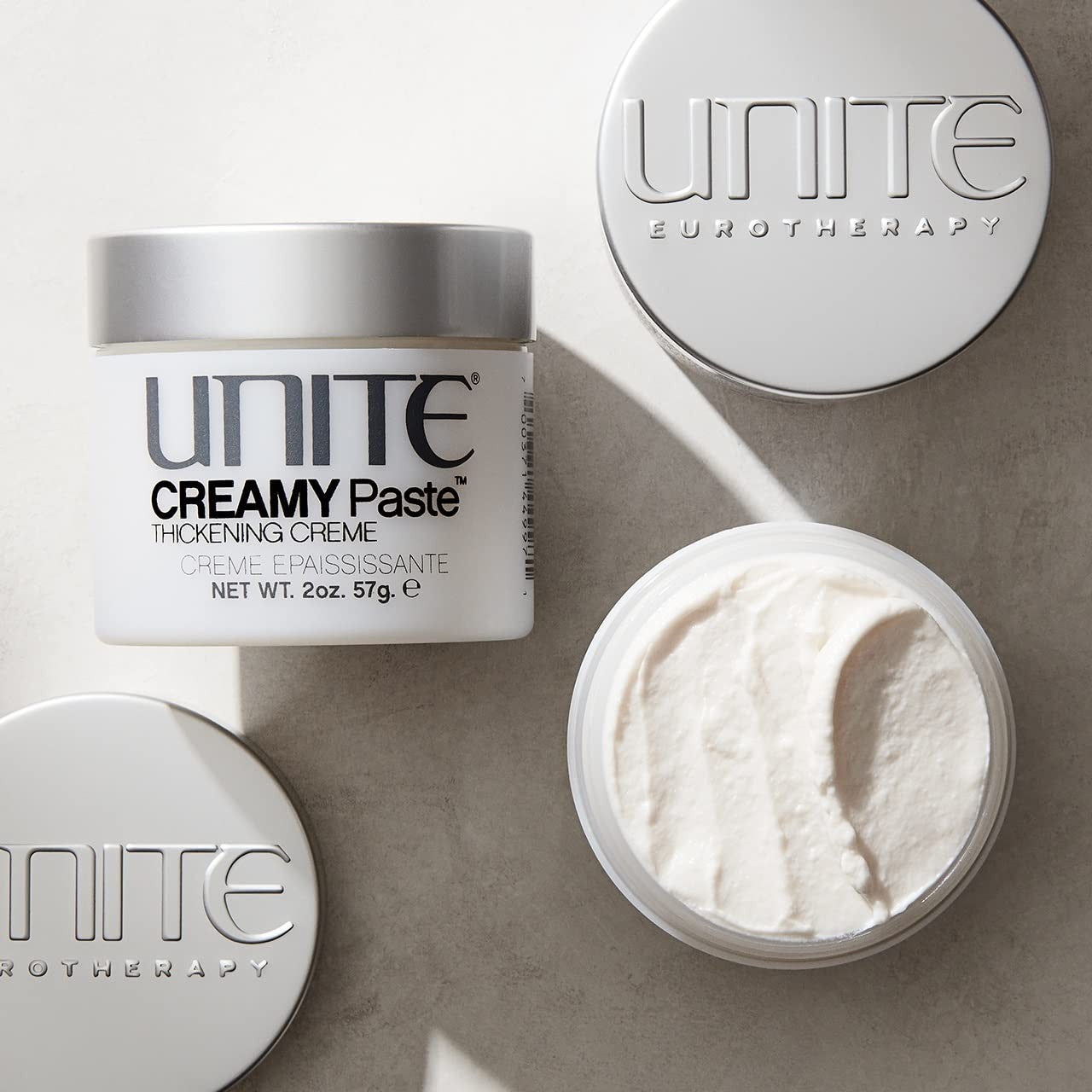 UNITE Hair Creamy Paste styling cream for thickening, texture, and definition, shown in a jar with product applied on hair