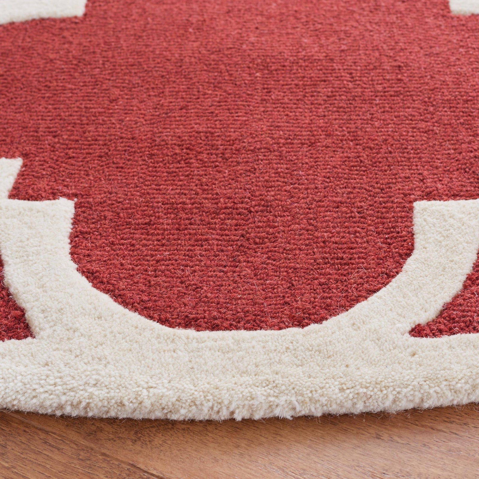 Handmade Safavieh Cambridge Collection 6-foot round Moroccan rug with rust and ivory geometric pattern on textured fabric.