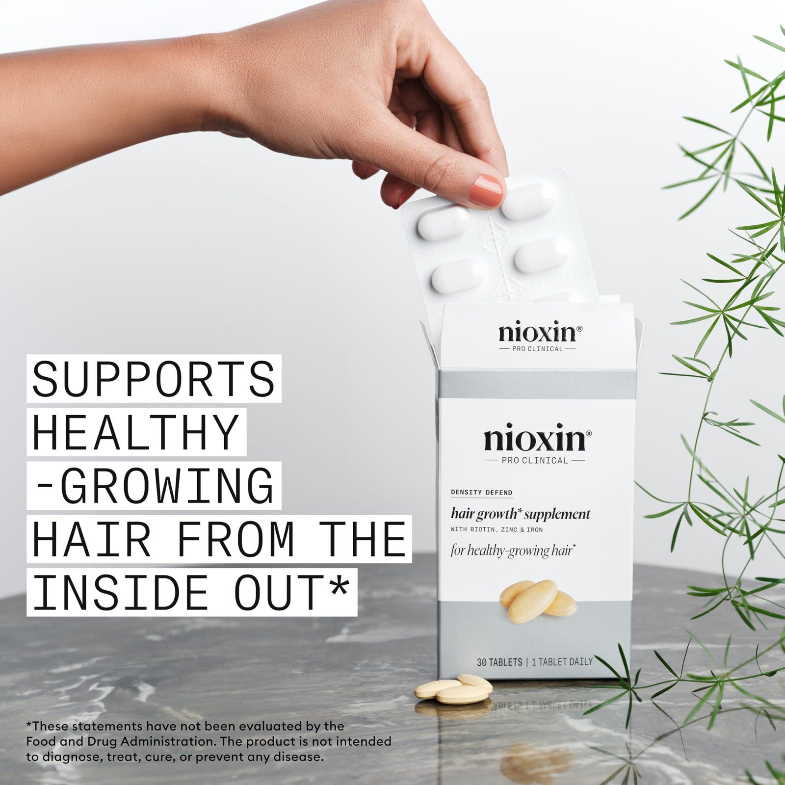 NIOXIN Density Defend hair growth supplements bottle with biotin, zinc, and iron capsules on a white background.