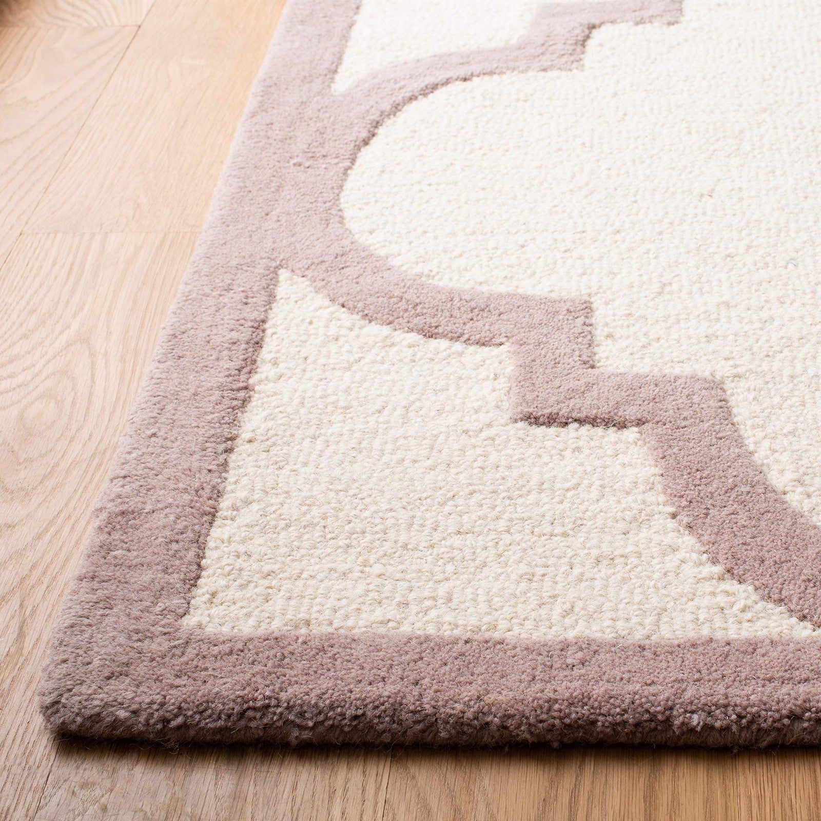 Handmade Safavieh Cambridge Moroccan rug in 5x8 ivory and beige with intricate geometric patterns on a woven surface.