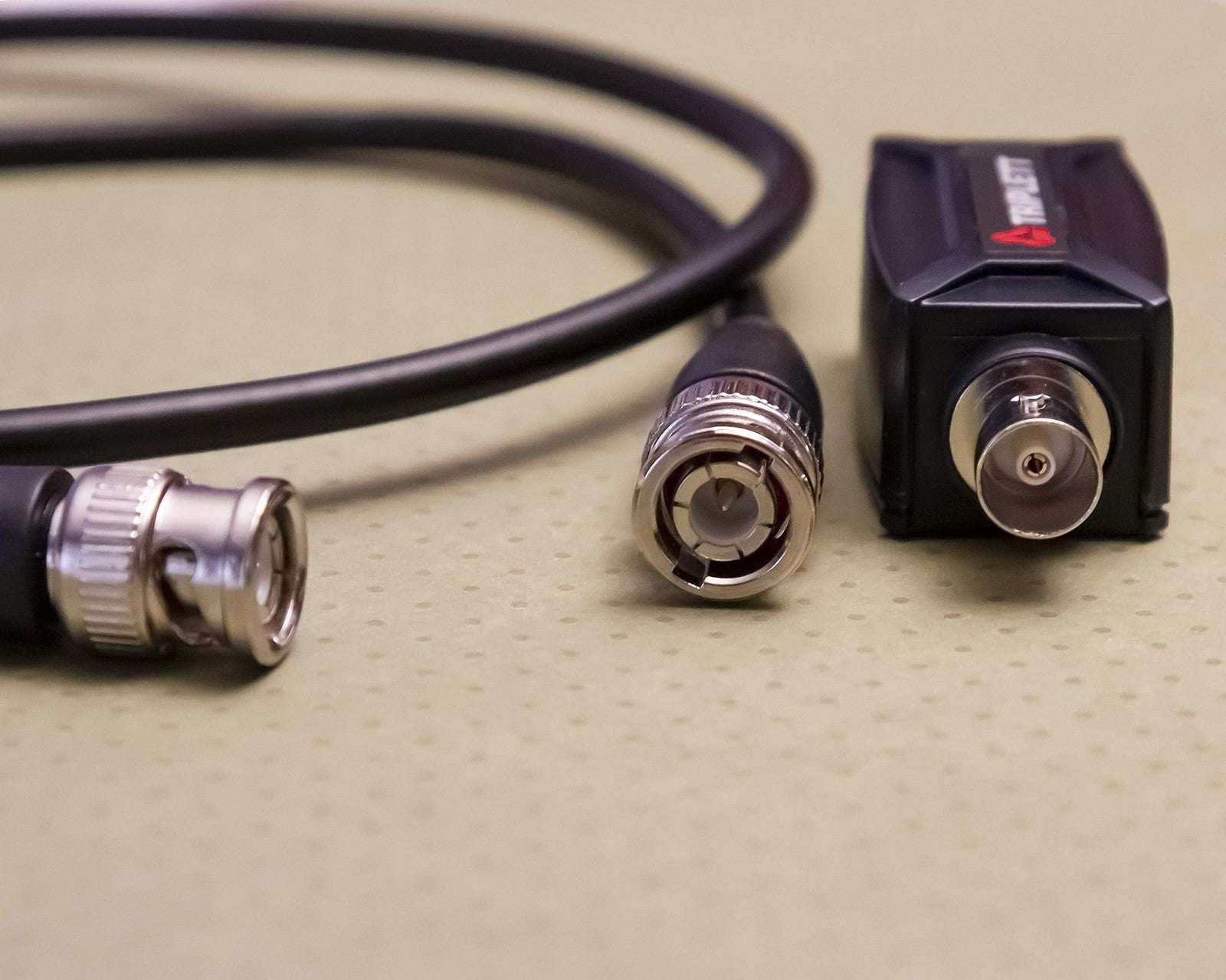 Triplett GEM IP camera signal extender over coax cable, showing device connected for long-distance data transmission up to 984 feet.