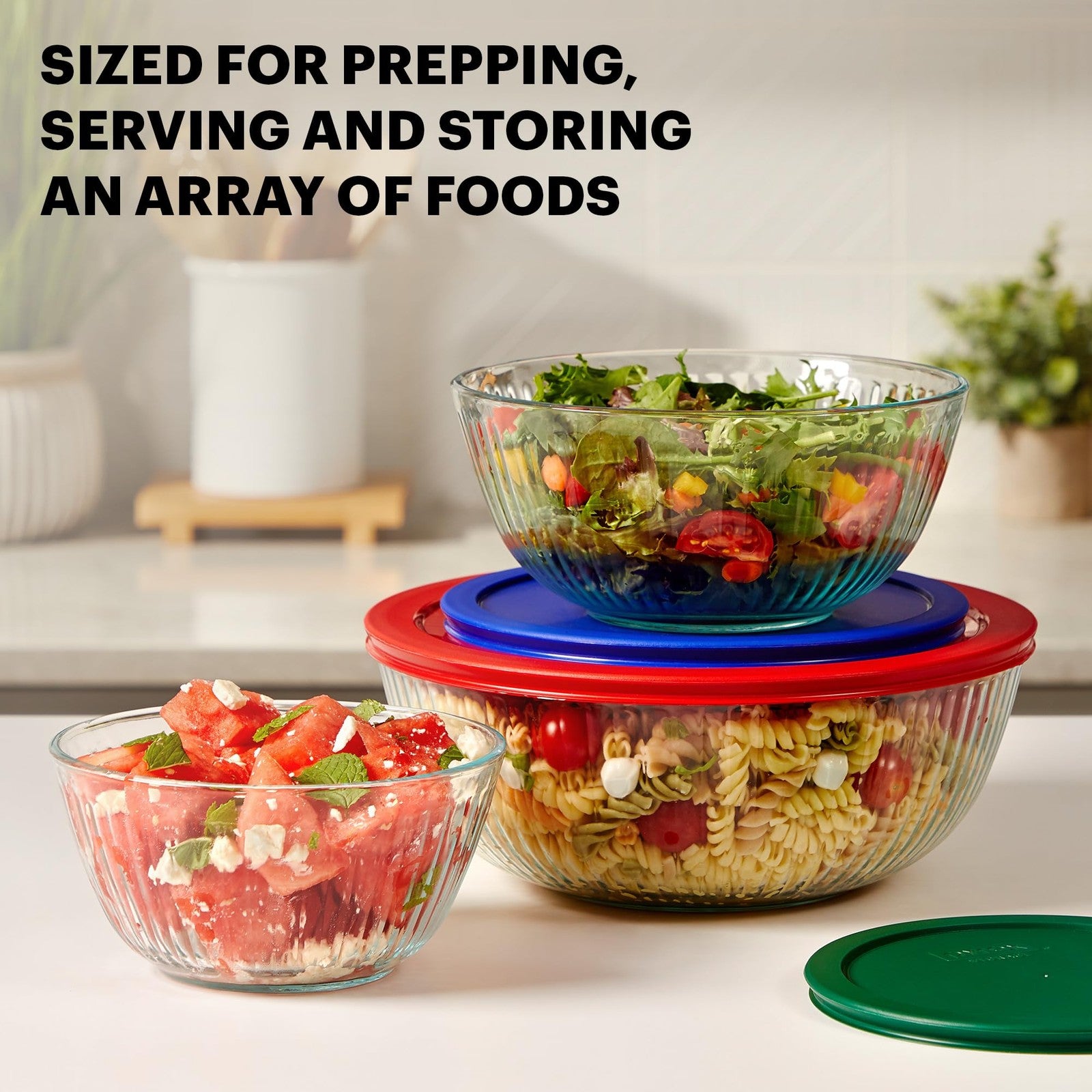 Pyrex sculpted glass mixing bowl set with lids, including three bowls for prep, mixing, and storage, featuring a stylish design.