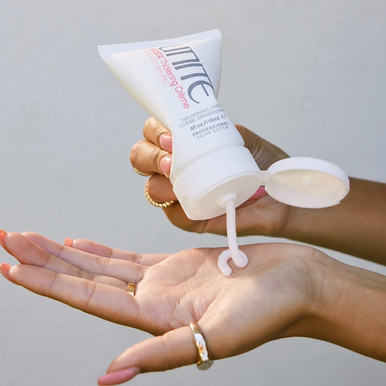 UNITE Boosta Thickening Crème for fine, limp hair, volumizing styling cream in a tube with a white cap.