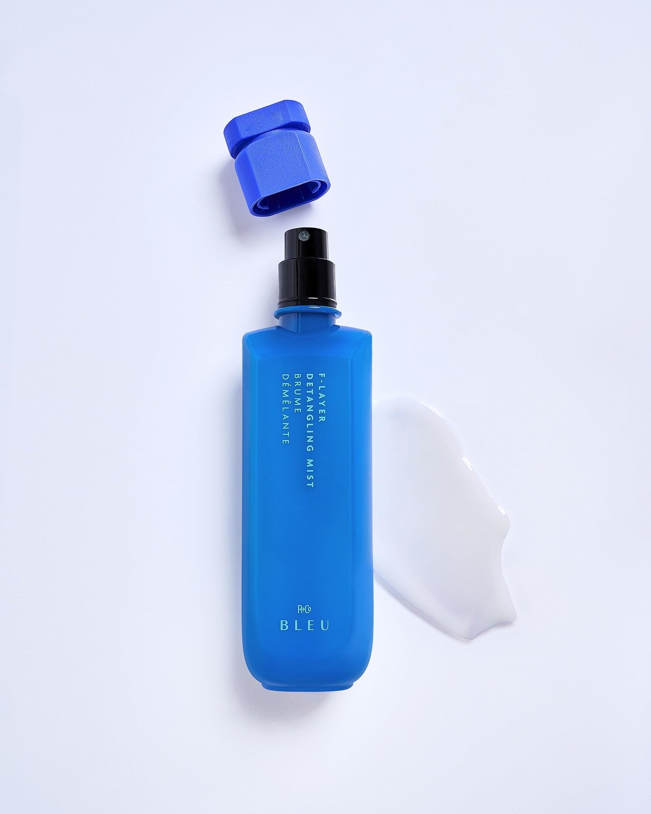 R+Co BLEU F-Layer Detangling Mist in a 6.8 oz spray bottle, shown with the product label and packaging.