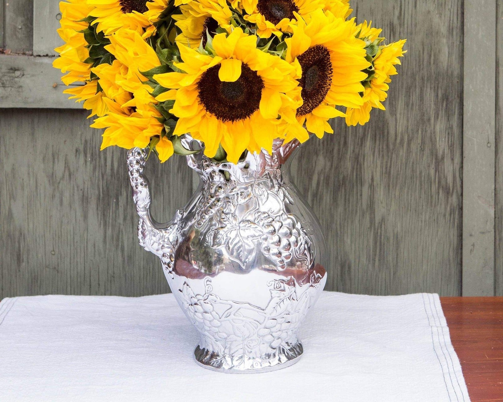 Arthur Court metal vineyard pitcher with grape pattern, sand-cast aluminum design featuring a decorative grape motif.