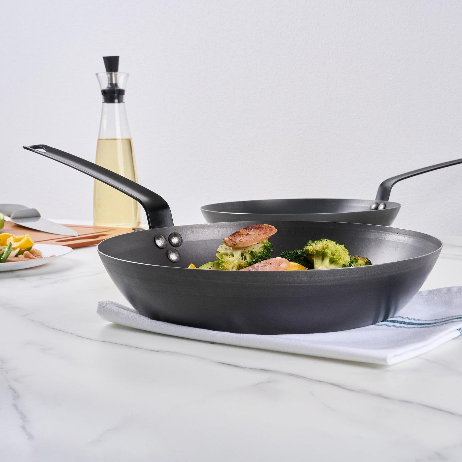 Restaurantware Met Lux 12-inch lightweight frying pan with triple-rive induction-ready design, shown with a cooked meal inside.