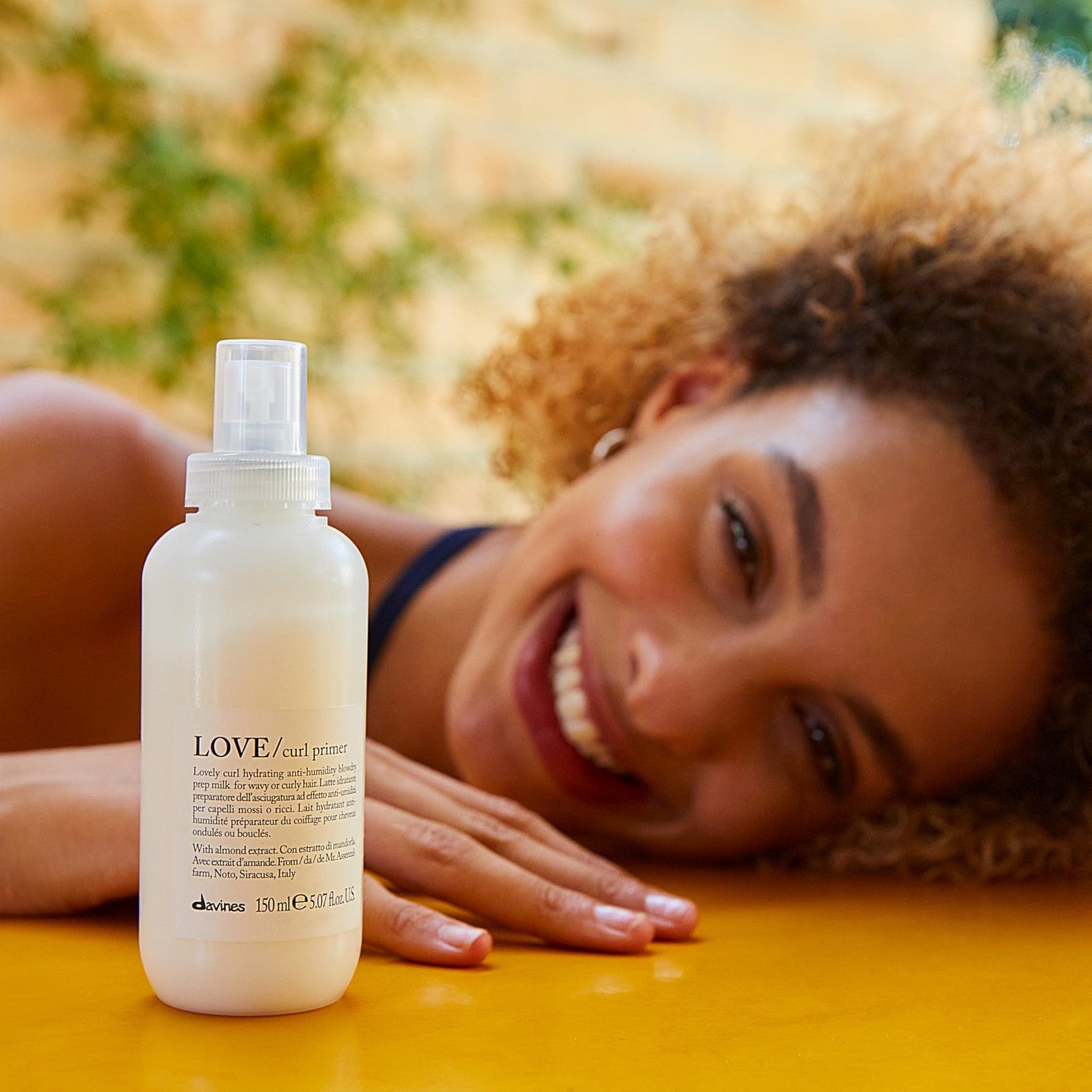Davines LOVE Curl Primer moisturizing anti-humidity heat protectant spray bottle for curly hair on a white background.