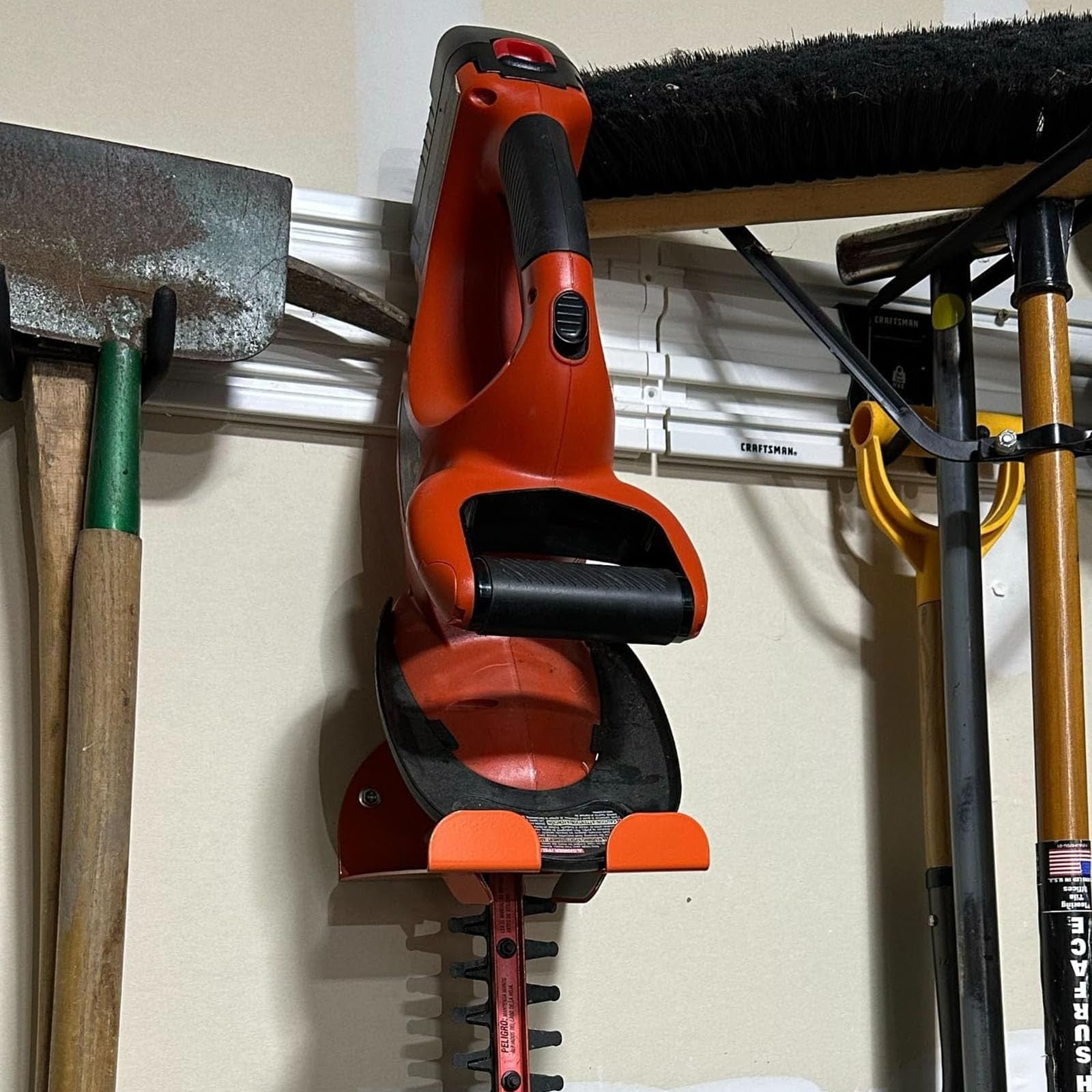 iulrtba upgraded wall mount trimmer rack holding a heavy-duty weed eater in a garage storage setting