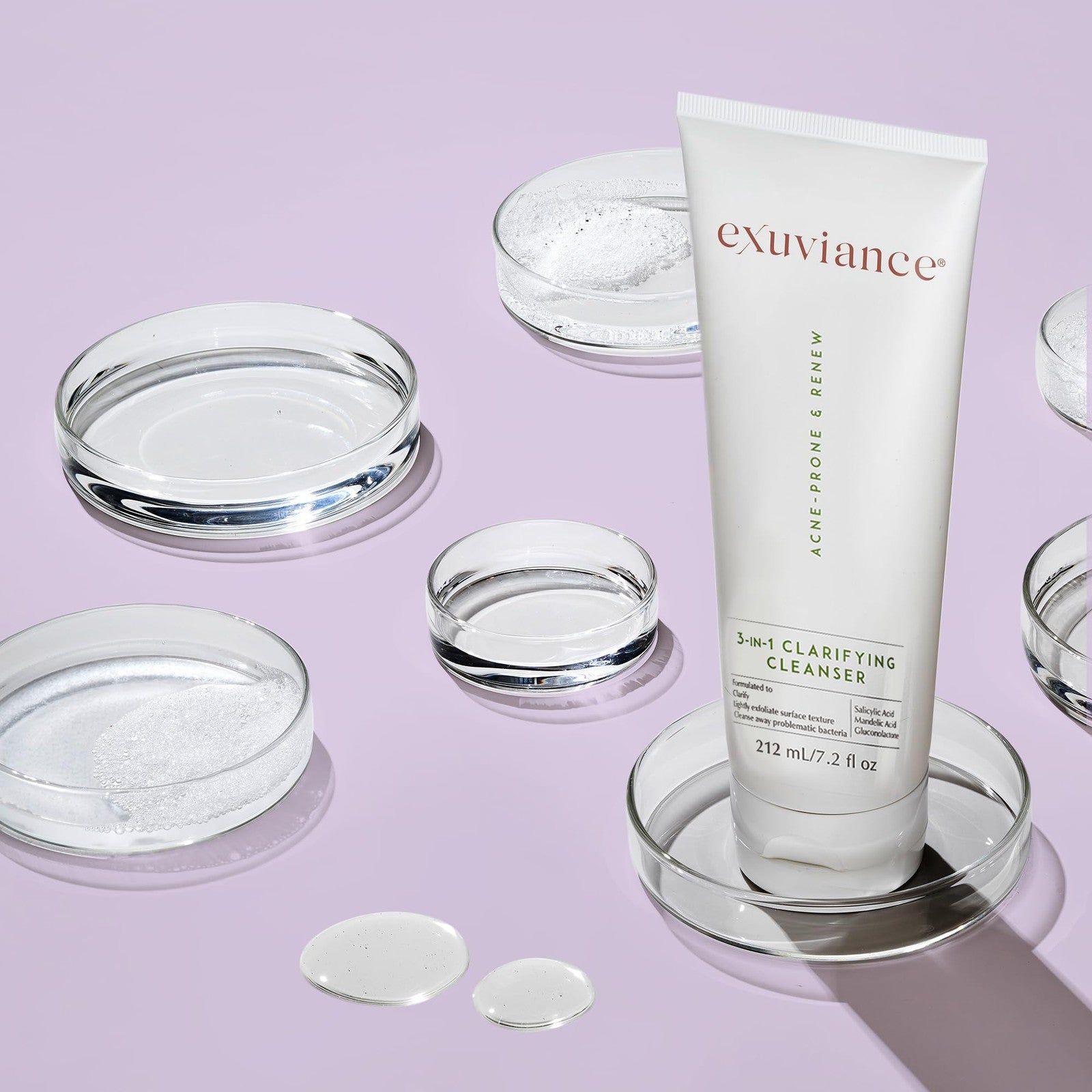 EXUVIANCE 3-in-1 Clarifying Anti-Aging Cleanser for acne-prone skin with salicylic acid, showing the cleanser bottle and product label.
