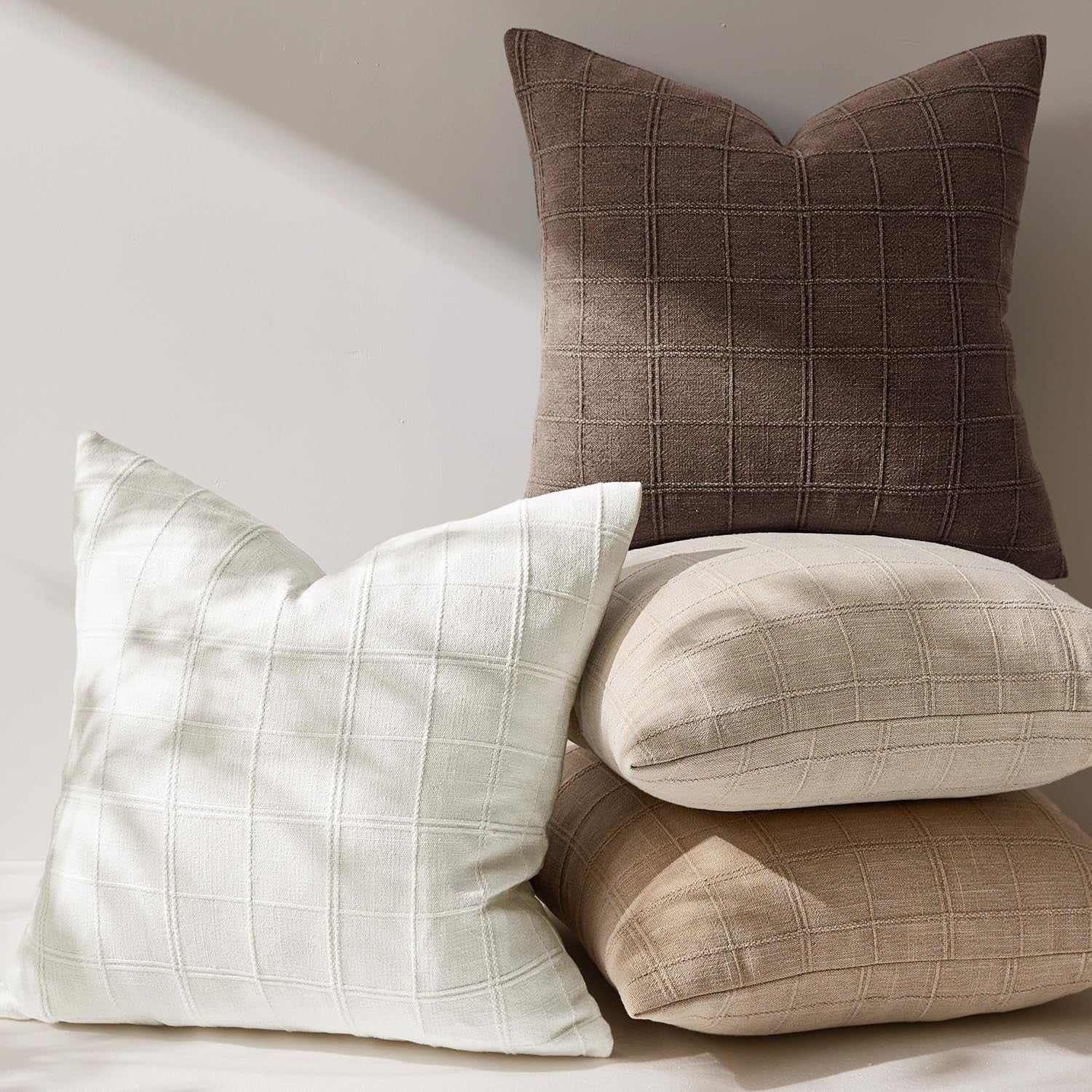 Woaboy linen check throw pillow cover in brown with farmhouse modern boho vintage style, 22x22 inches on a sofa.