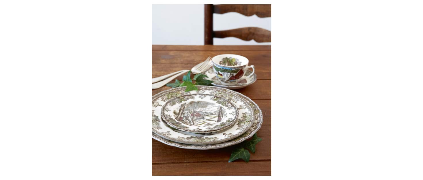 Johnson Brothers Friendly Village 20-piece dinnerware set with multicolor patterns, including plates, bowls, and cups arranged neatly.