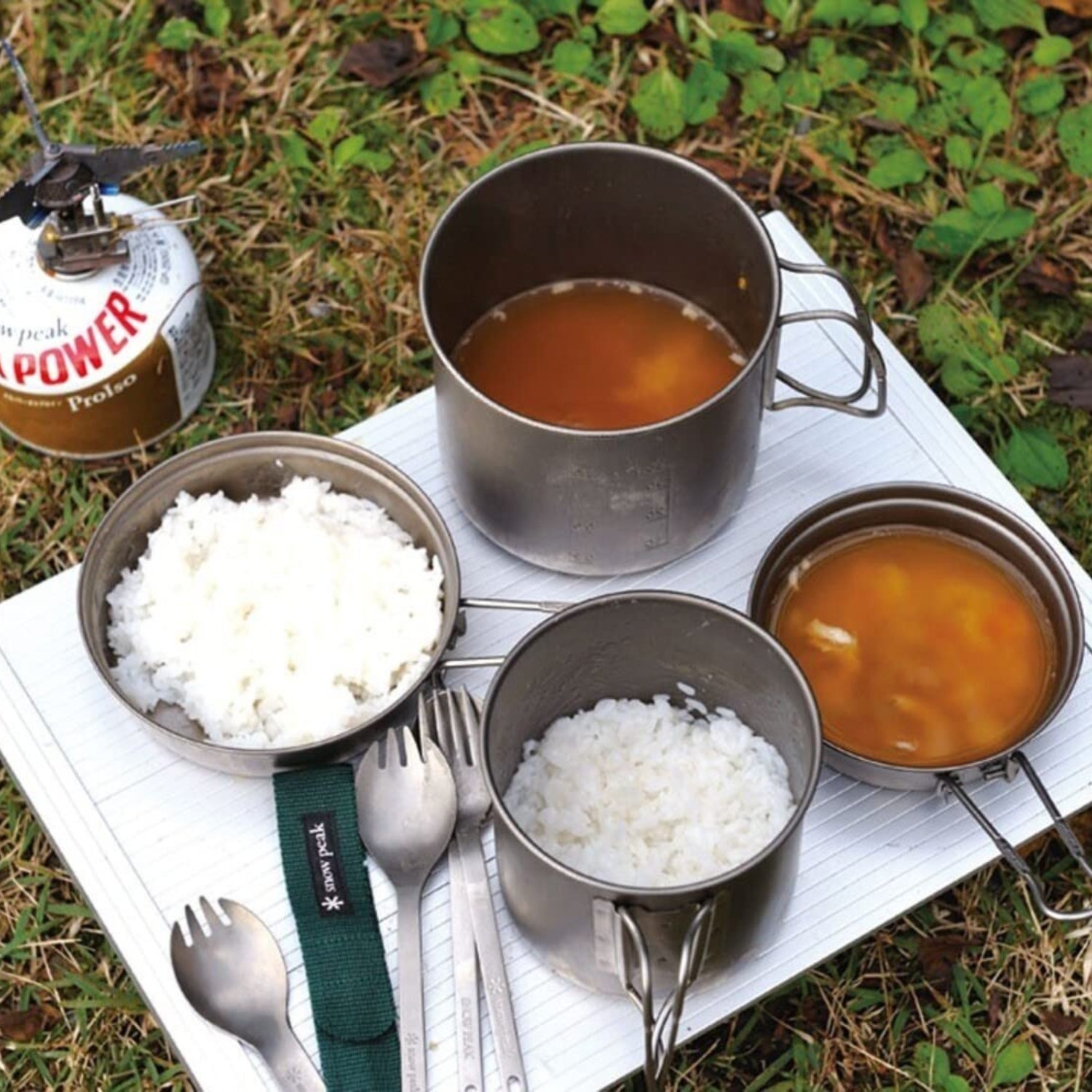 Snow Peak Trek 1400 aluminum cookset with pots and lids for camping and outdoor cooking, lightweight and durable.