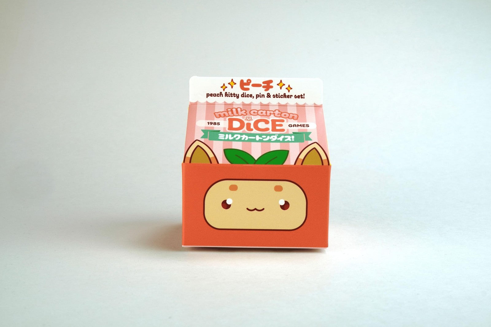 1985 Games Peach Cat milk carton-shaped dice set for DND, featuring 10 colorful gaming dice inspired by milk cartons.