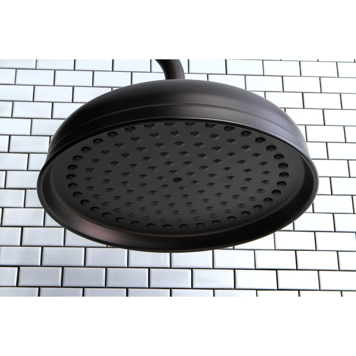 Kingston Brass Victorian raindrop shower head, 10-inch, oil rubbed bronze finish, mounted on a shower arm with water flowing.