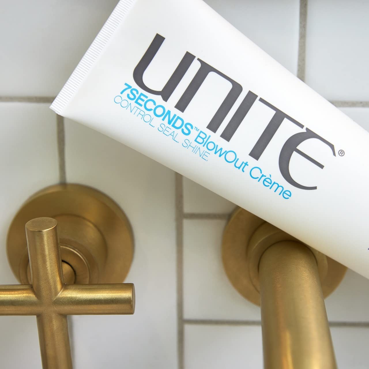 UNITE Hair 7SECONDS BlowOut Crème bottle with label, showcasing lightweight frizz control and shine for blow-drying hair.