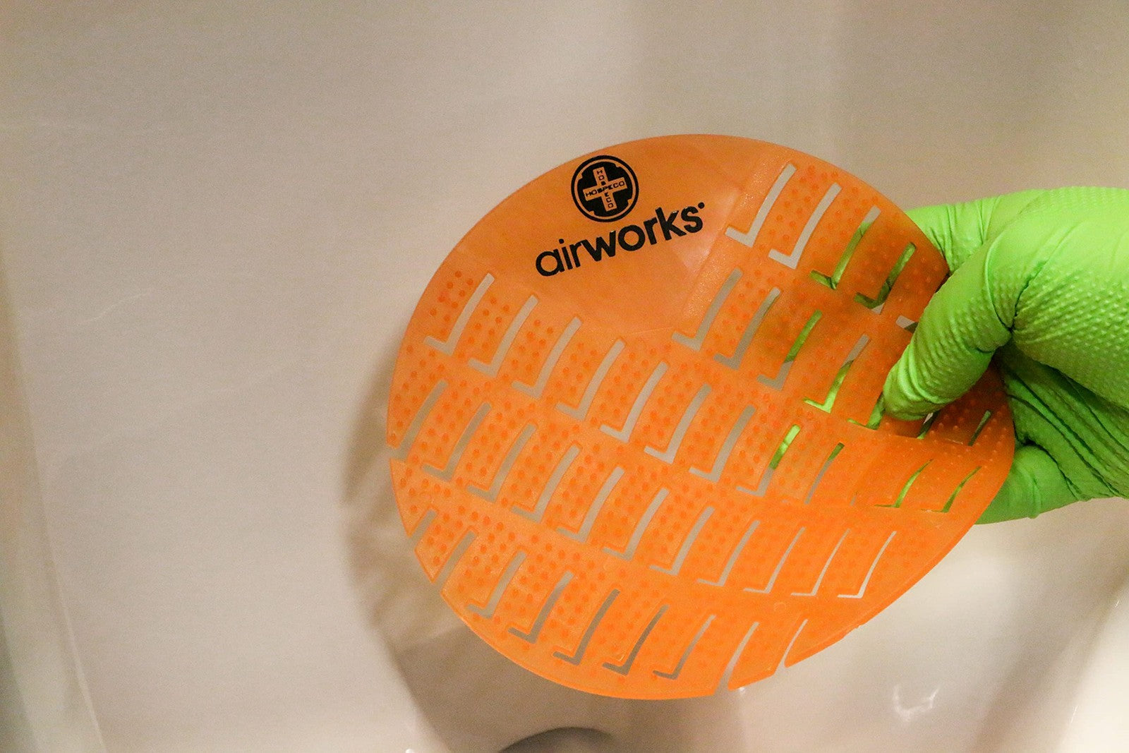 Set of 10 Airworks CC-007 urinal deodorizer screens in Mango Orange scent, designed to freshen and deodorize urinals.