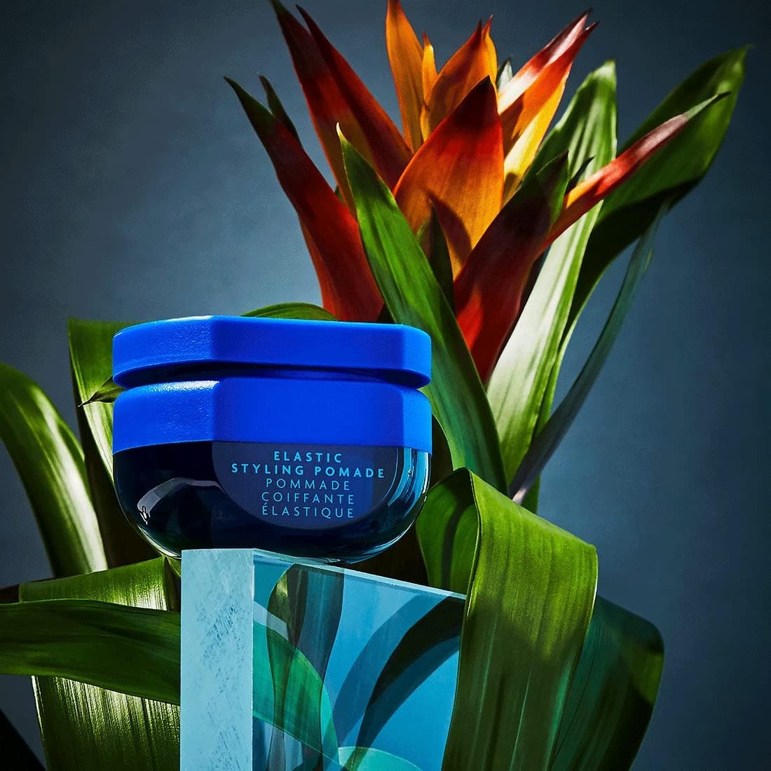 R+Co BLEU Elastic Styling Pomade with a person styling hair, showing its texture and ability to add piecey texture and separation.