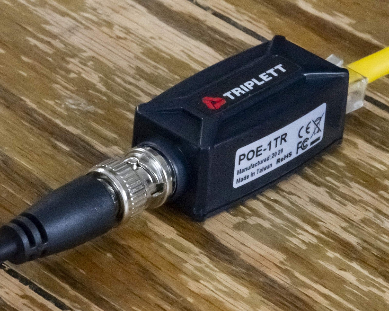Triplett GEM IP camera signal extender over coax cable showing the device connected to coax cables for long-distance data transmission.