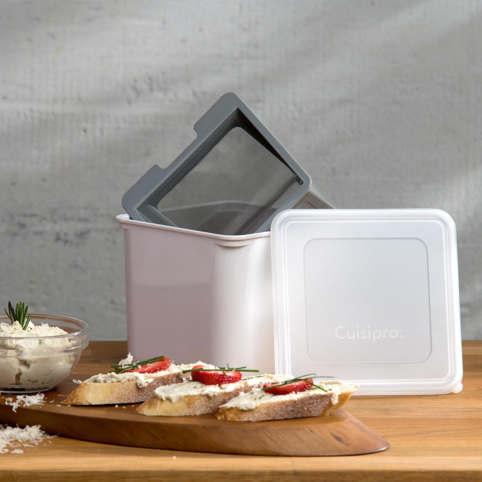 Cuisipro white yogurt cheese maker with strainer and lid, showing the compact kitchen appliance for homemade cheese.