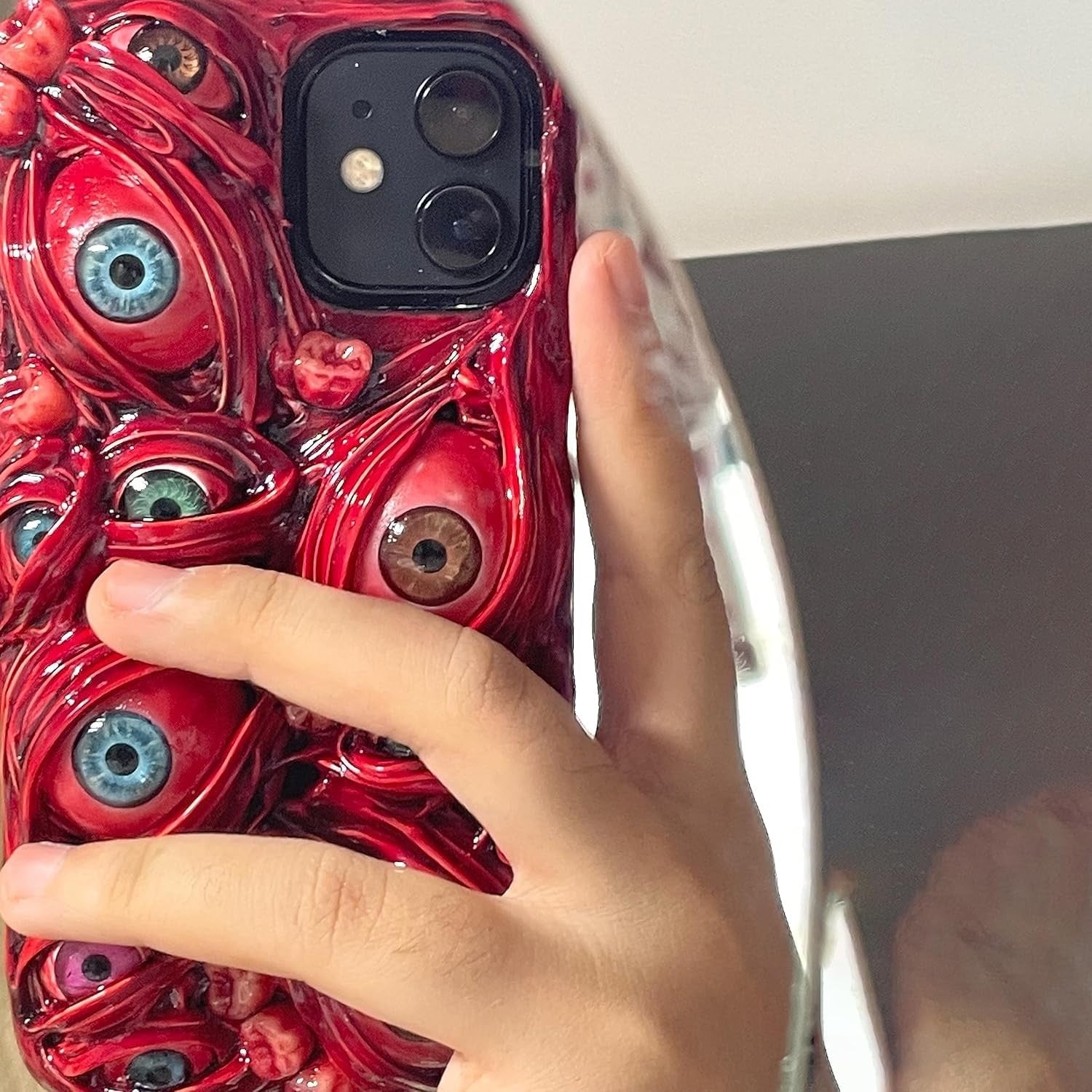 TRADAY iPhone 16 Pro horror phone case with creepy 3D eyes and scary design, featuring detailed textured surface.