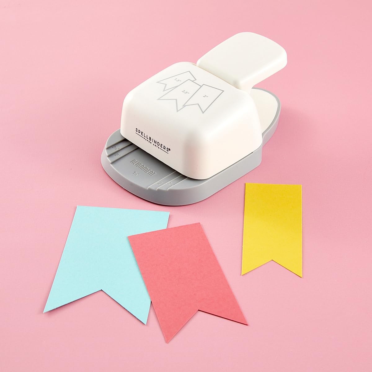 Spellbinders T-065 3-in-1 Banner Punch for paper crafting, showing the punch tool with paper banners ready to cut.