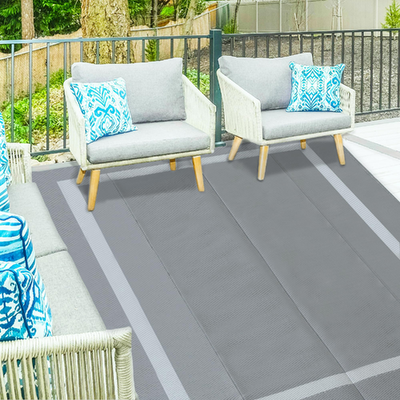 Ogrmar 6x9 ft reversible outdoor patio rug with waterproof plastic straw design on a wooden deck surface.