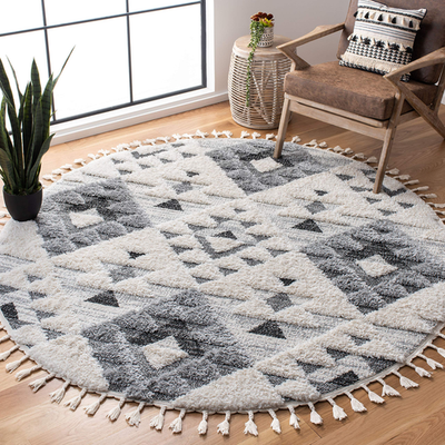 Safavieh Moroccan Tassel Shag round area rug in ivory and grey with boho tassel border, 53-inch diameter.