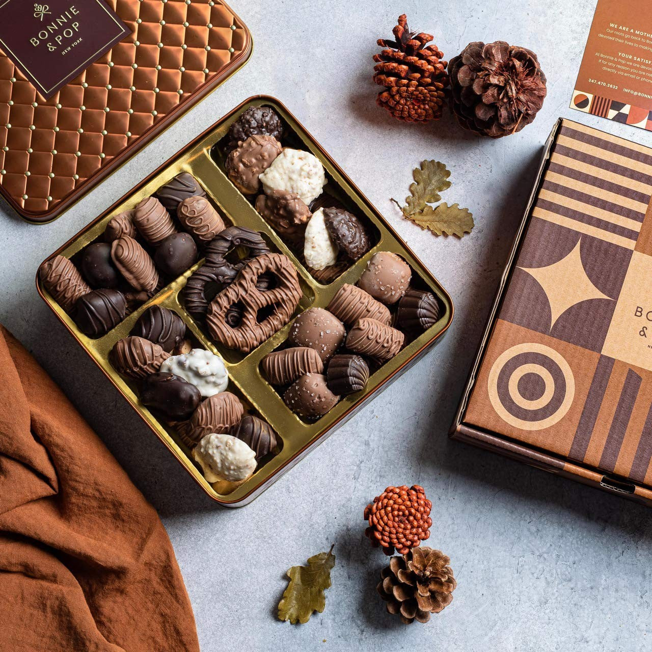Chocolate gift basket with assorted candies and gourmet snacks from Bonnie and Pop, displayed on a decorative platter.