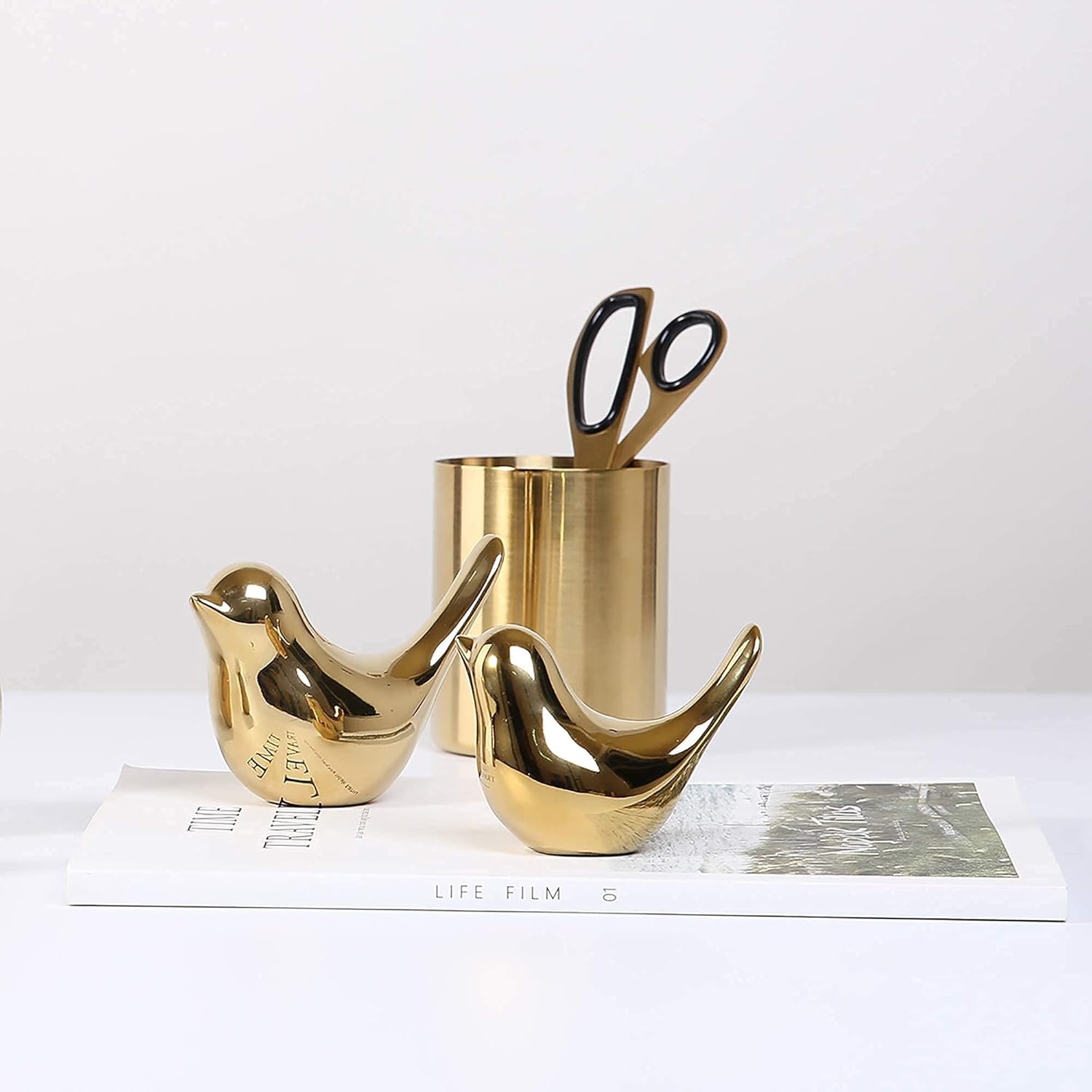 Gold small bird statues by FANTESTICRYAN, modern home decor featuring two elegant bird figures on a sleek surface.