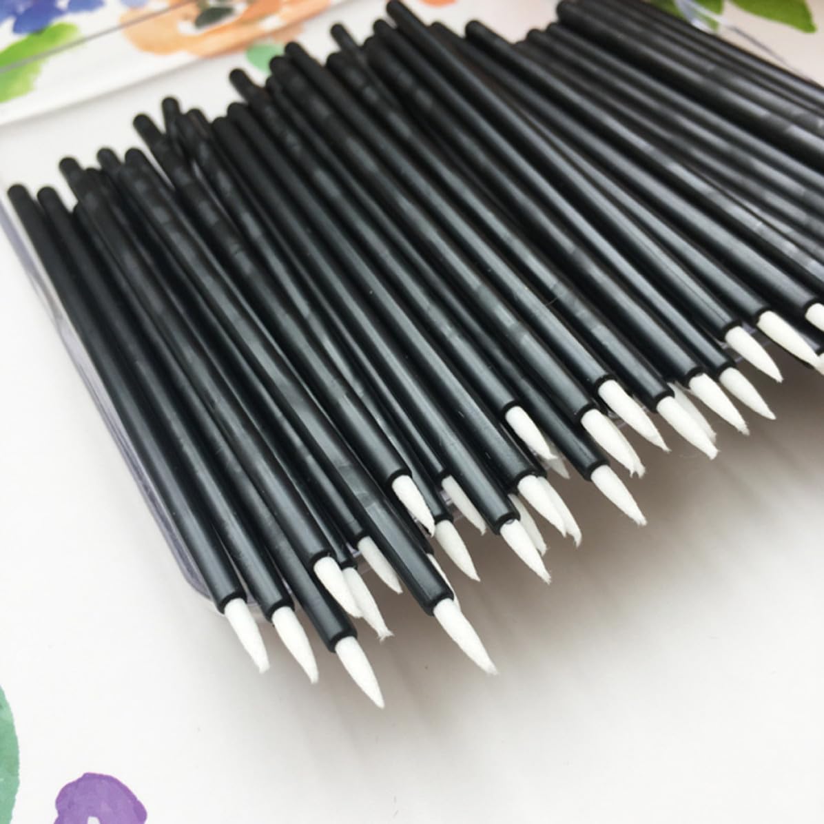 Set of 100 WOFASHPURET disposable eyeliner brushes with thin black tips for precise makeup application.