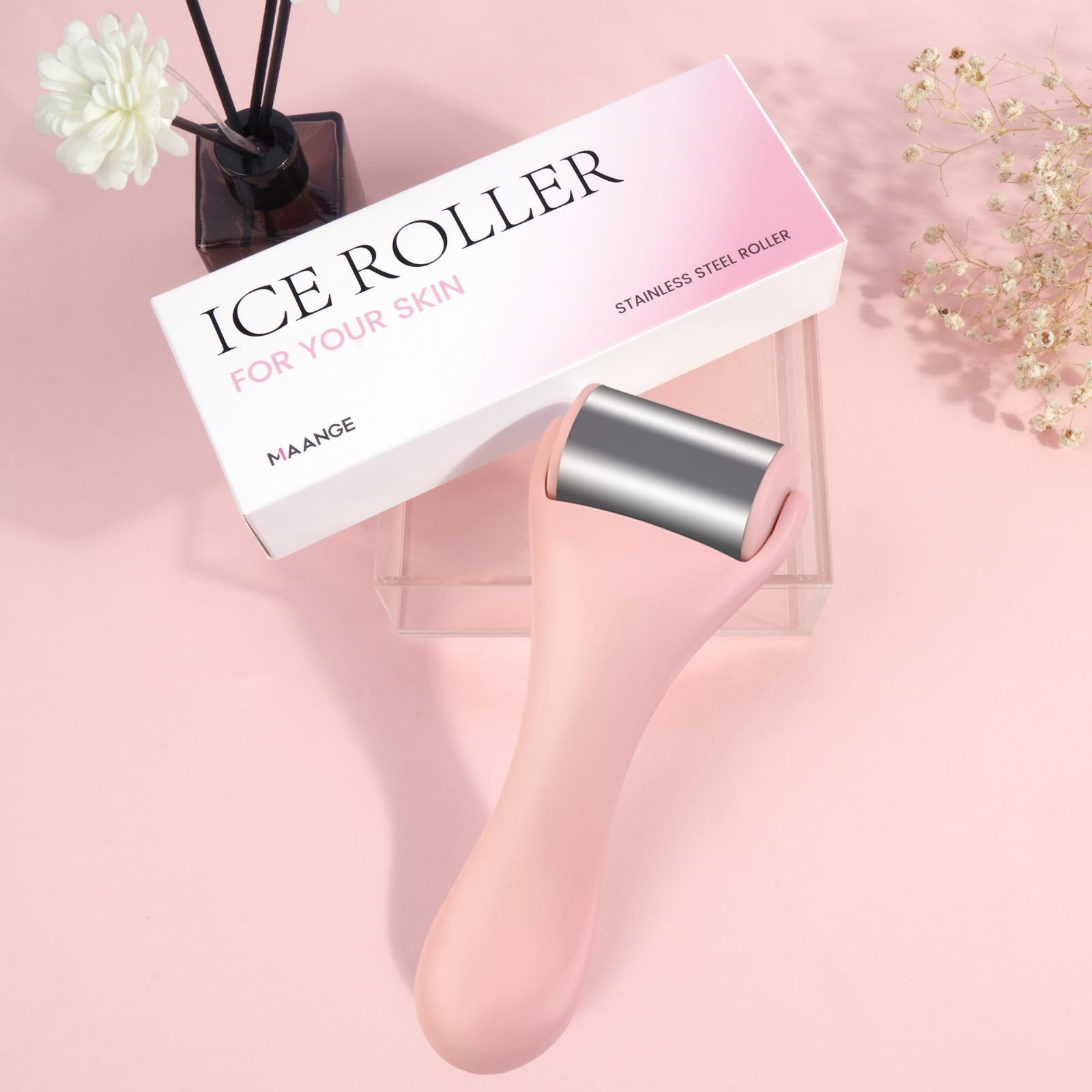 Pink MAANGE stainless steel face ice roller for beauty, showing the roller with a pink handle and textured surface for skin cooling.